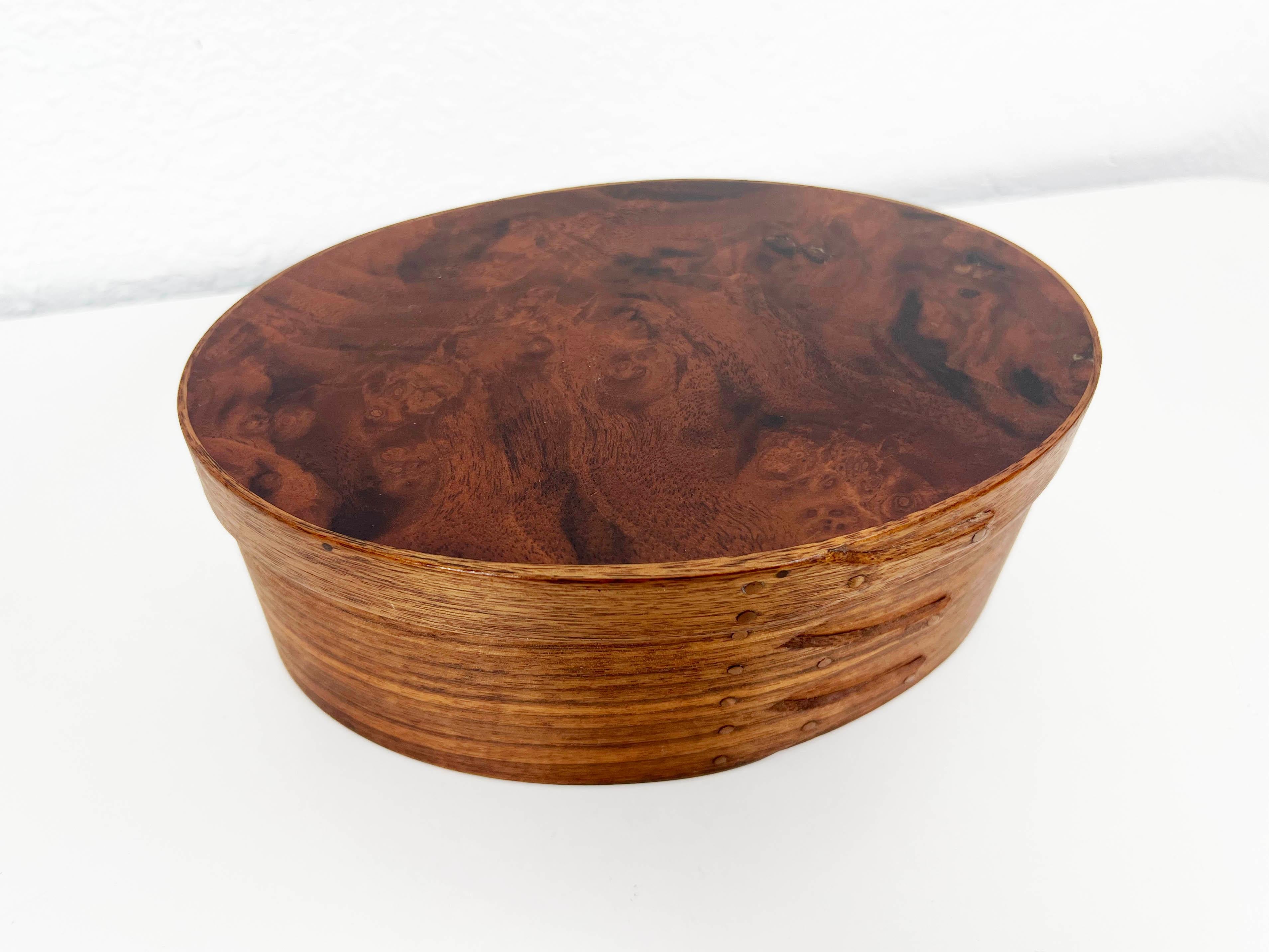 Vintage hand made lidded oval box crafted in teak and walnut burl wood with copper nail detail. Signed.

Dimensions: 7.5