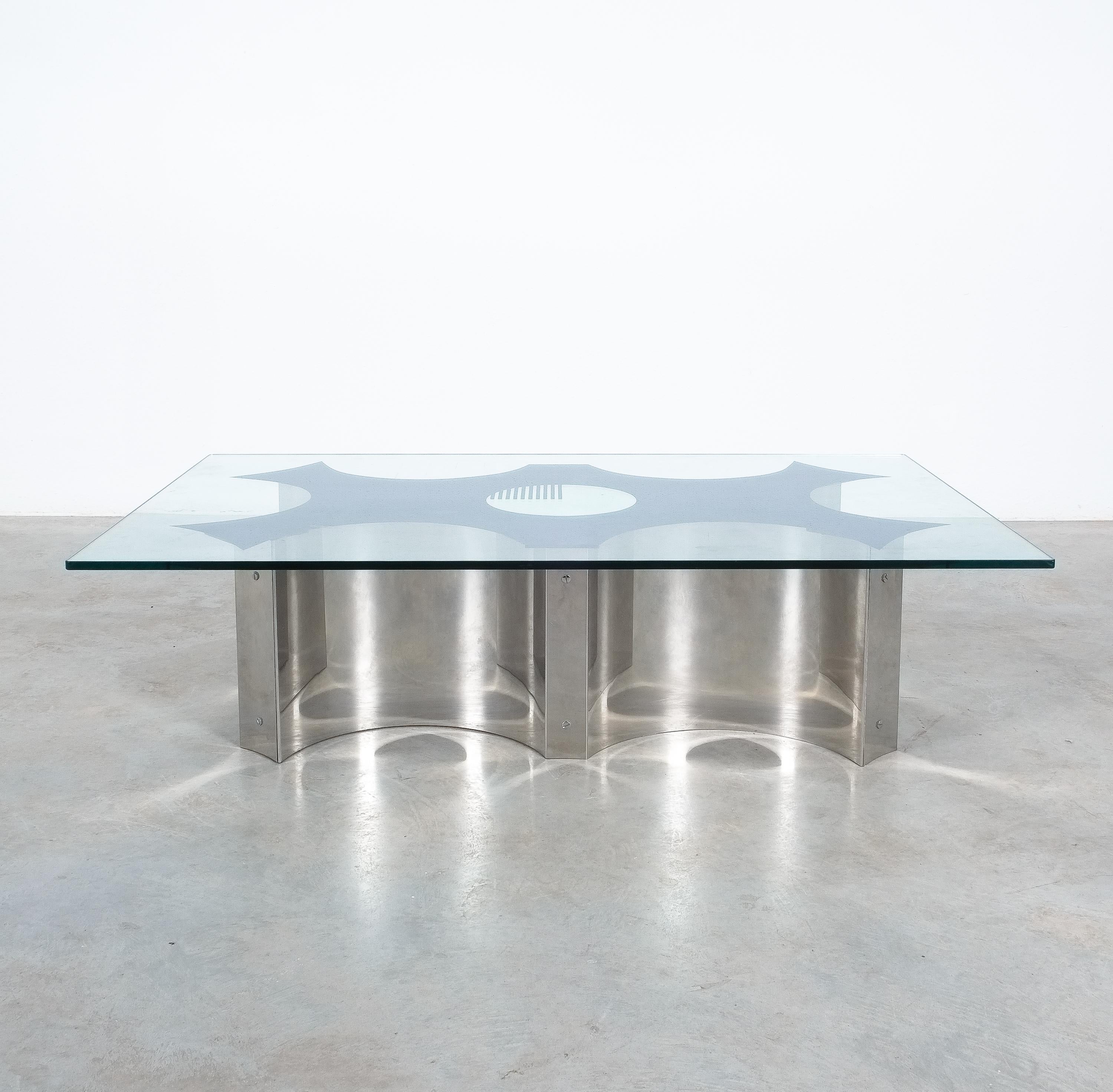 Unique coffee table by Eugenio Davico with the original pattern mirror glass top, Italy 1970

Very cool and rare cocktail table with a heavy glass top on a bent stainless steel base. The glass has got a mirror back face depicting the outlining of