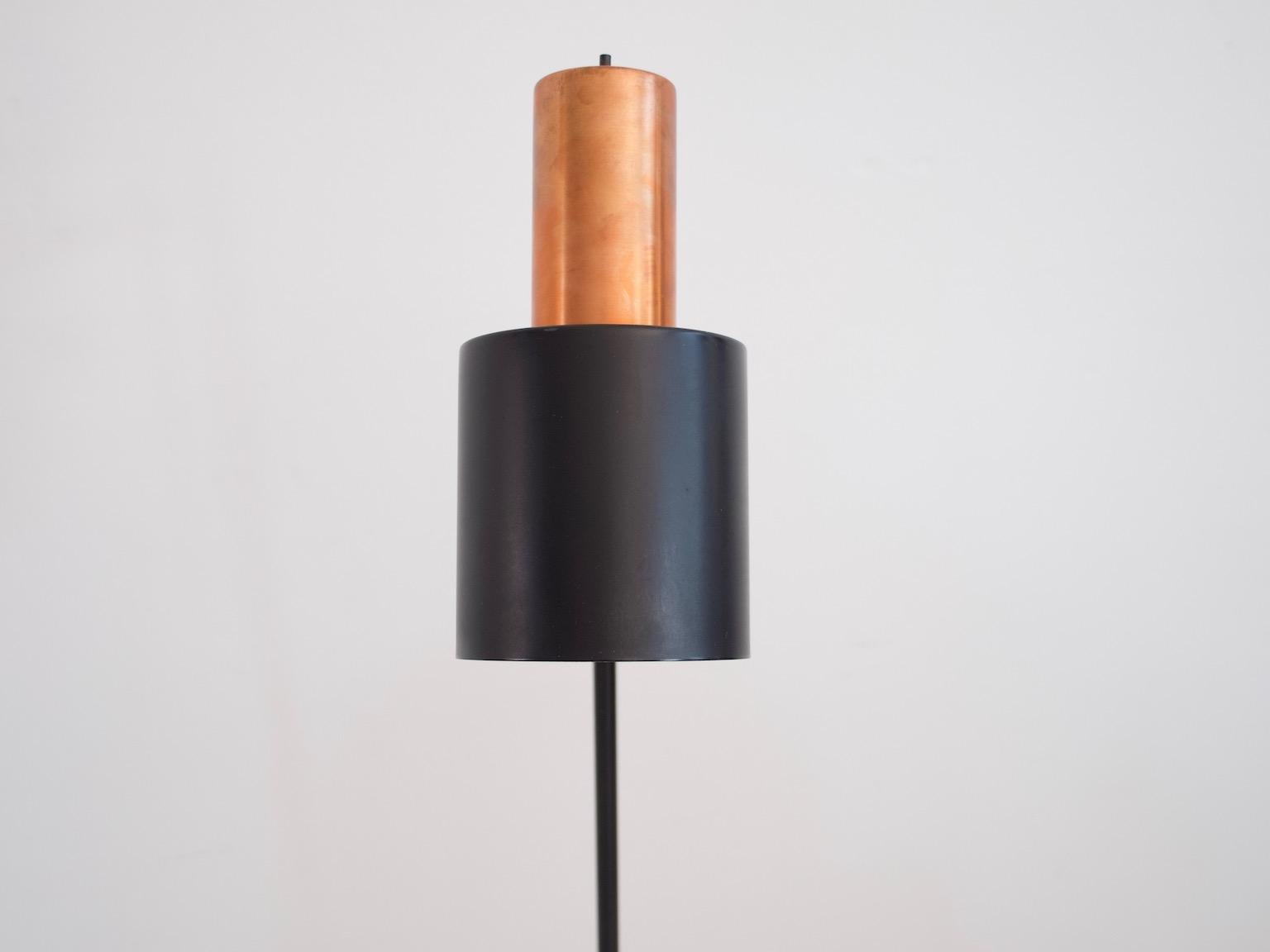 The 'Studio' floor lamp was designed by Jo Hammerborg for Fog and Mørup in 1963. It features copper and black painted metal shade and stand.
  