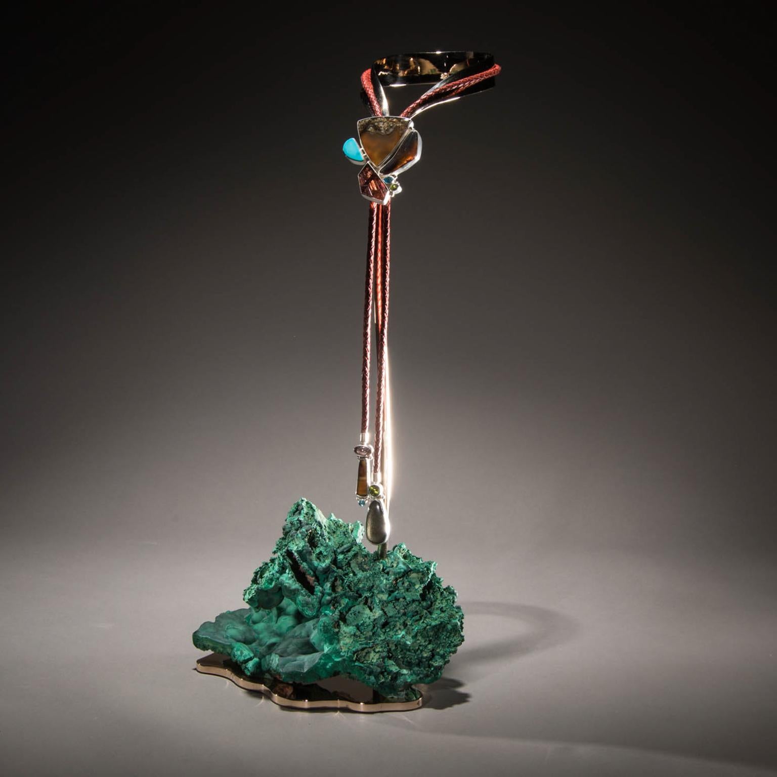 Montana Agate Bolo Tie On Malachite.

The most essential elements of life wind through Studio Greytak’s Montana Agate Bolo Tie on Malachite.  A lariat necklace featuring a polished triangle of earthy agate lies between the pristine blue of watery