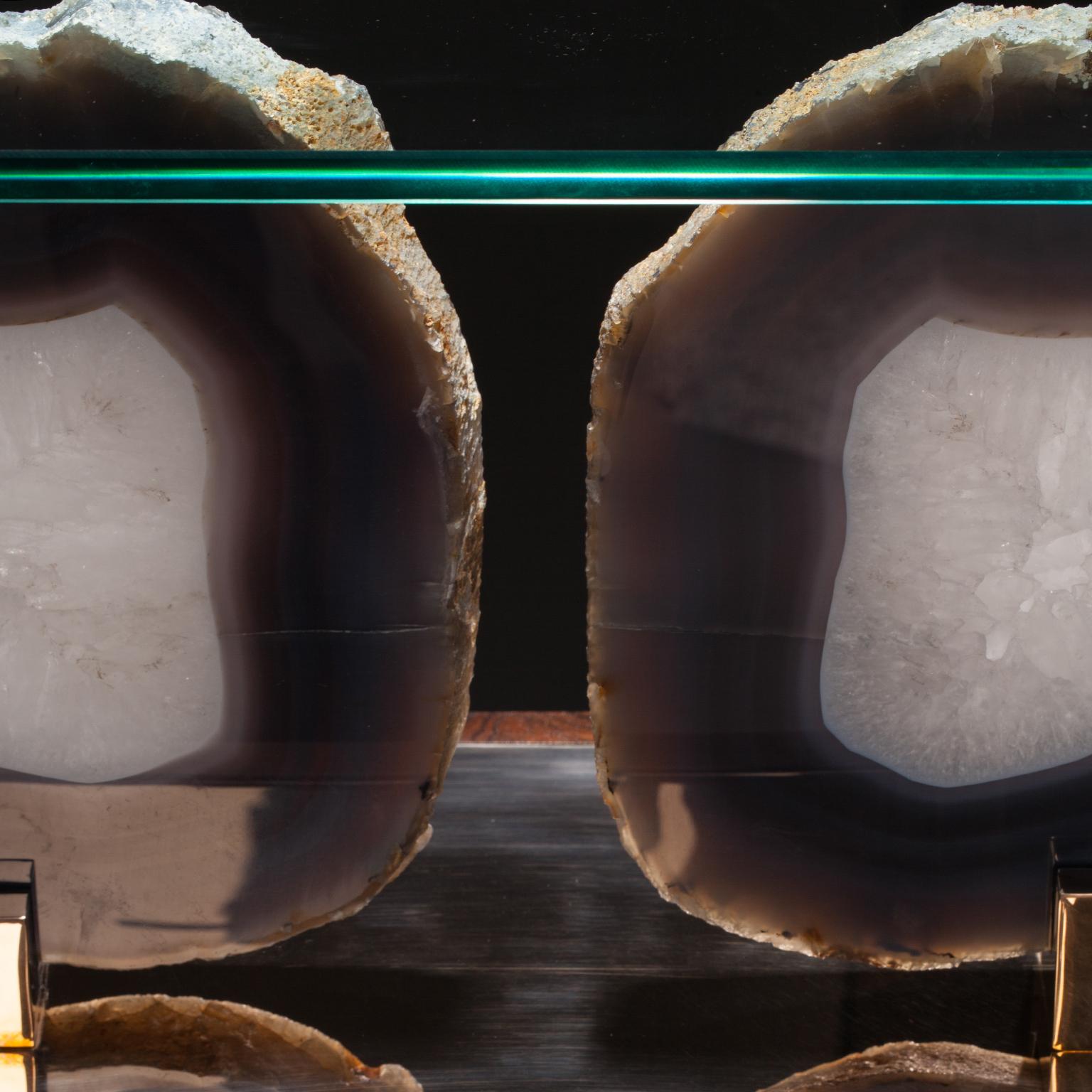 Paris Console 2

Brazilian agate is revered around the world for its clarity and color. In Studio Greytak’s Paris Console 2 a bookended pair of icy blue agates are set atop a mirror finish of polished bronze like summer clouds floating above a clear