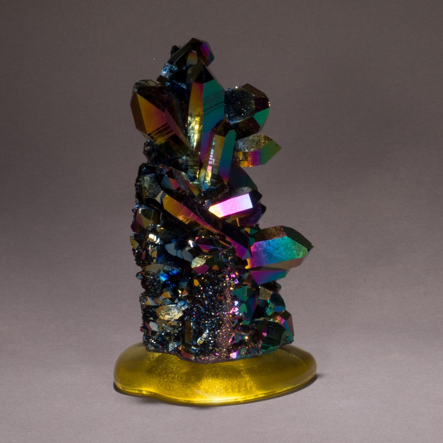 Titanium quartz on cast glass

Titanium quartz, sometimes called rainbow aura quartz, is created when titanium oxide is bonded molecularly with a natural quartz crystal. Studio Greytak has created a fun and playful art piece with their titanium