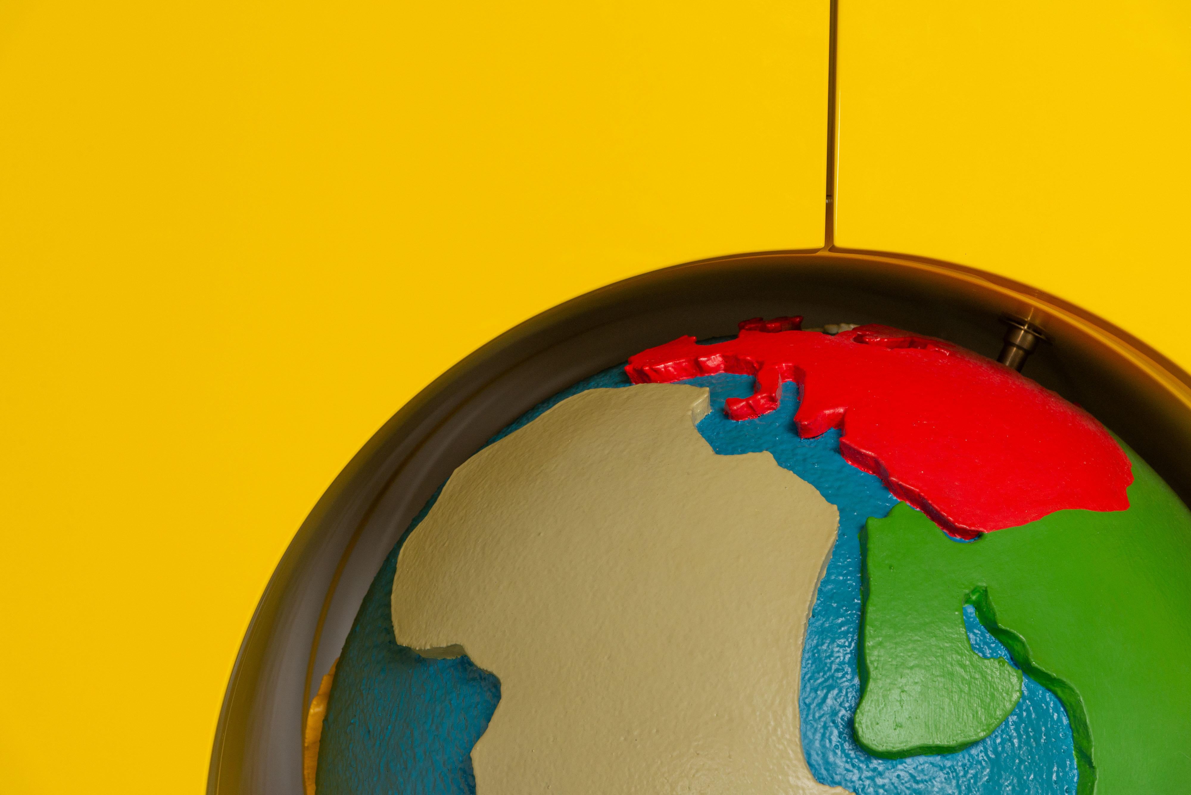 Le meuble conteneur Globe est conçu par Studio Job pour Gufram avec un cadre en bois laqué disponible en jaune, avec un globe rotatif en polyuréthane souple, fini et décoré à la main avec du Guflac. Dédié à tous les voyageurs du monde, Globe a été