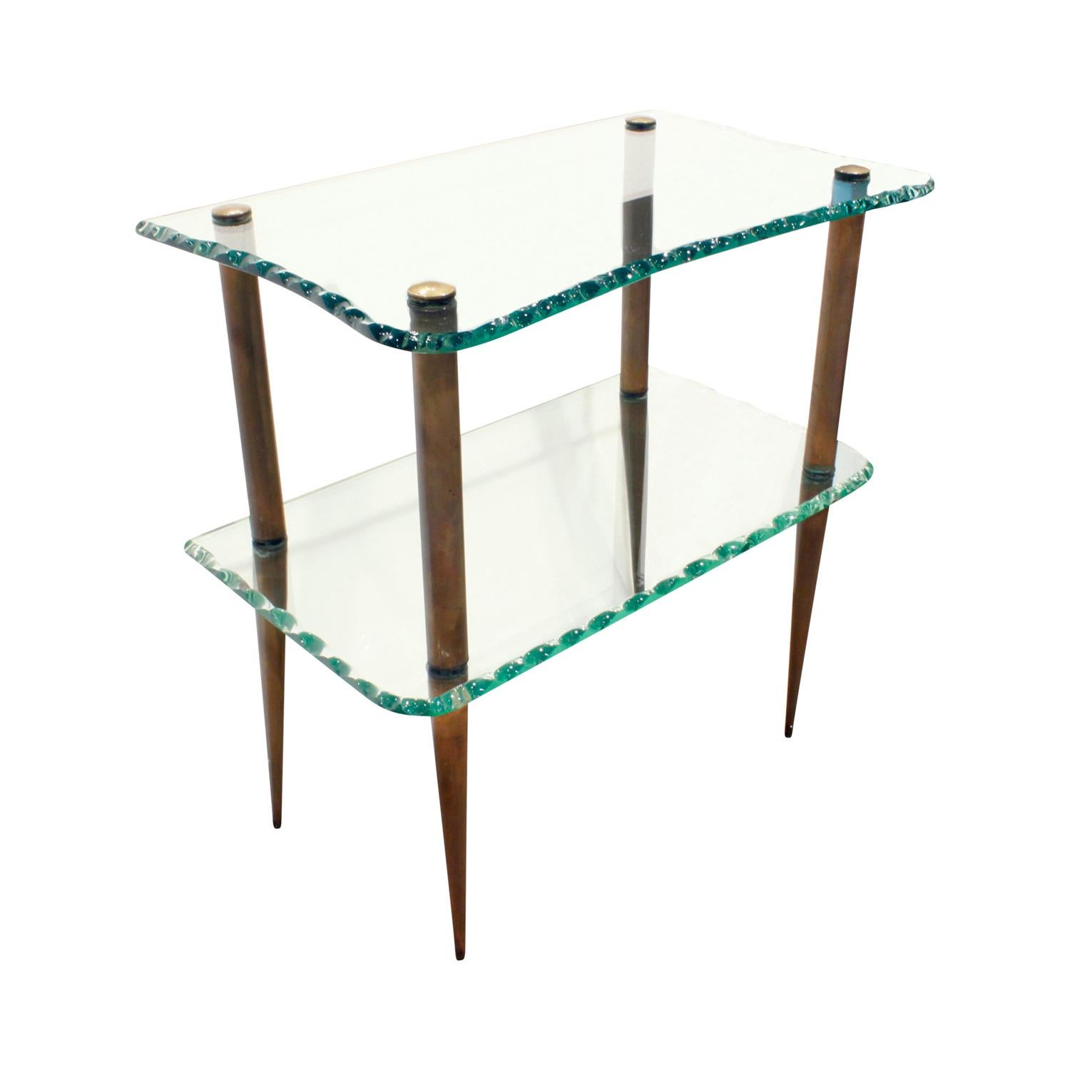 Elegant 2-tier console table with artisan crafted glass and brass tapering legs, Italian, 1950s.  This piece is absolutely stunning and would be a wonderful accent table in any room.