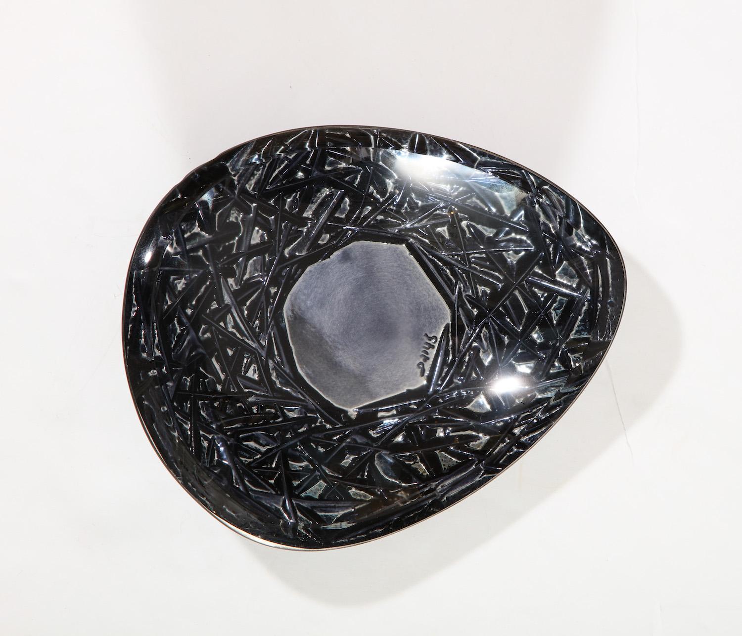 Irregularly- shaped, hand carved dish with deep engravings to underside, and dark coloring infused with metallic elements. Artist-signed on underside.