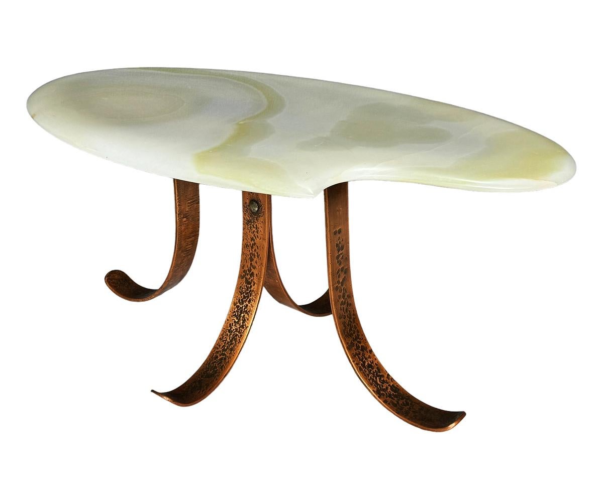 A gorgeous and sophisticated coffee table. Studio made circa 1970's . It features a hammered copper base with a sculptural green onyx oval top. Very well cared for condition. Signed by artist on bottom. 