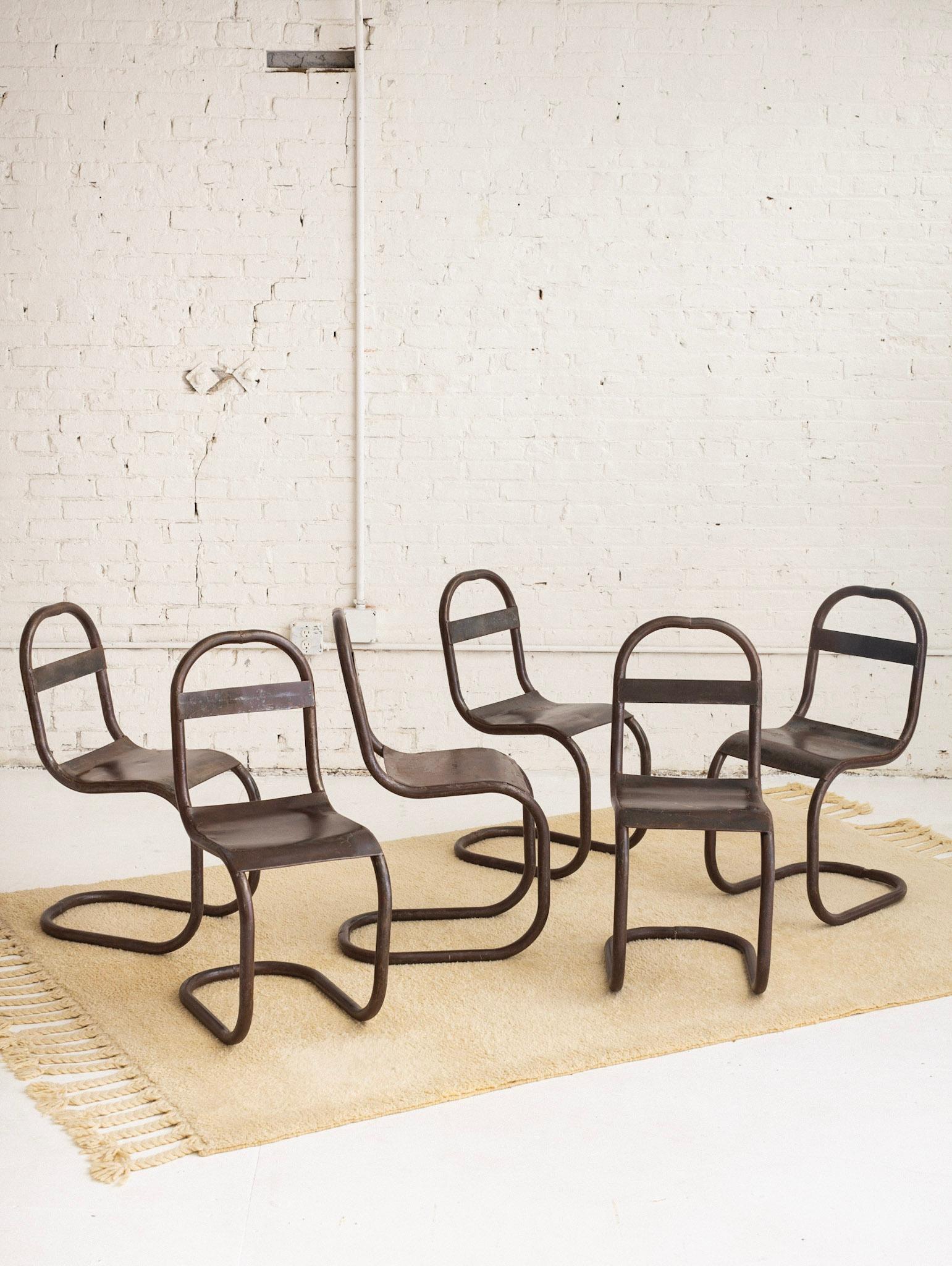 Set of 6 richly patinaed dining chairs. Studio made, exhibiting manufacturing details such as weld marks. Natural color variations throughout, ranging in rich brown tones. Cantilever silhouette. Each chair has its own unique markings and patina.