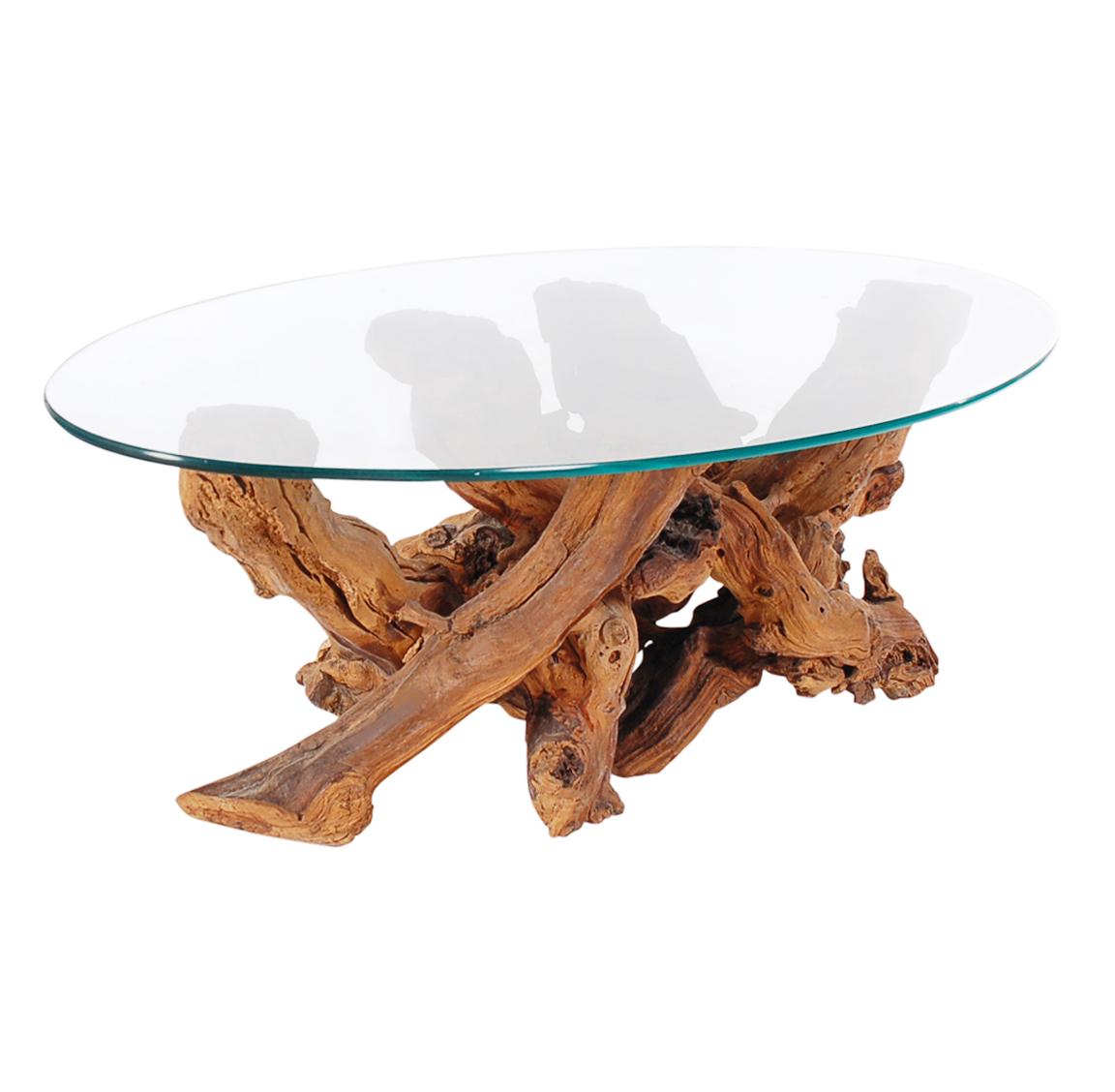 An oval vintage cocktail table or coffee table that was studio made in the early 1970s it features a sculptural solid driftwood base with clear glass top.
 