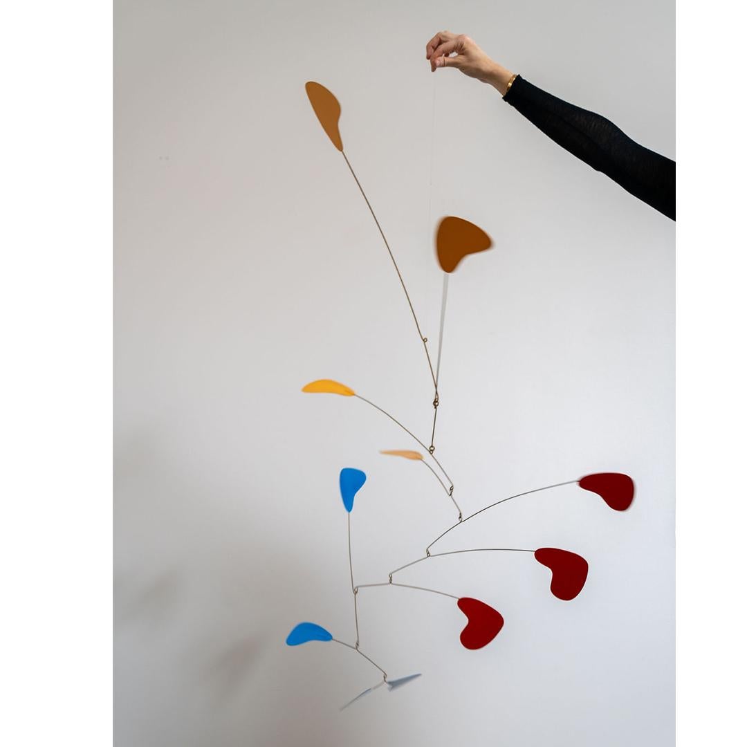 A studio-made modernist mobile; mustard yellow, blue, opium red. This innovative art form, rooted in the principles of modernism, emphasizes minimalism, abstraction, and the intrinsic beauty of materials, often resulting in mesmerizing kinetic
