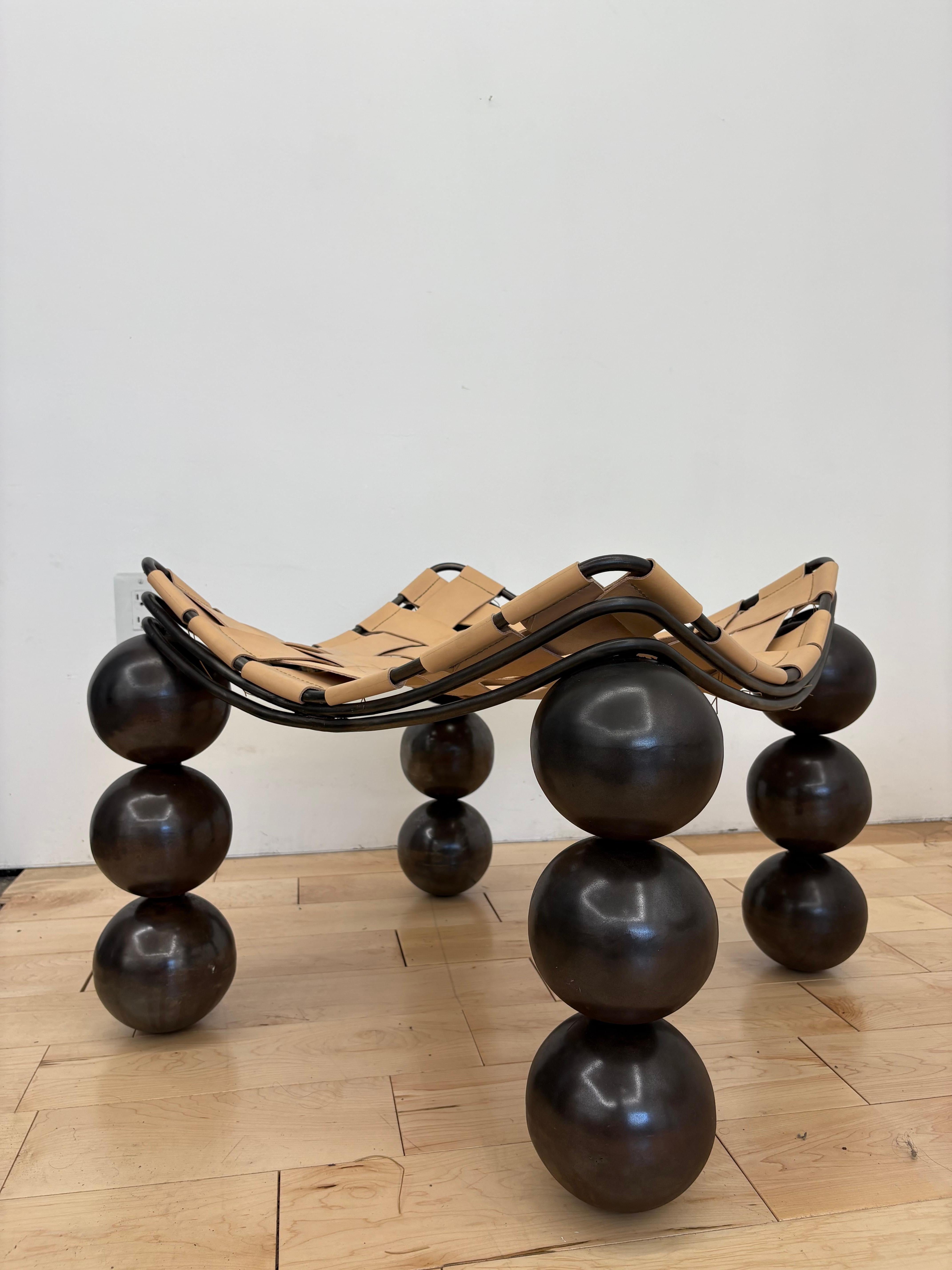 A striking studio-made sculptural ottoman or stool designed and handcrafted in Los Angeles by Joseph Dieppa of Dieppa Design. This contemporary modernist piece features a brutalist steel frame with a rich bronze patina, composed of rhythmic arches