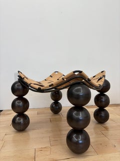 Pouf scultoreo di Studio A in acciaio e pelle conciata al vegetale con patina di bronzo