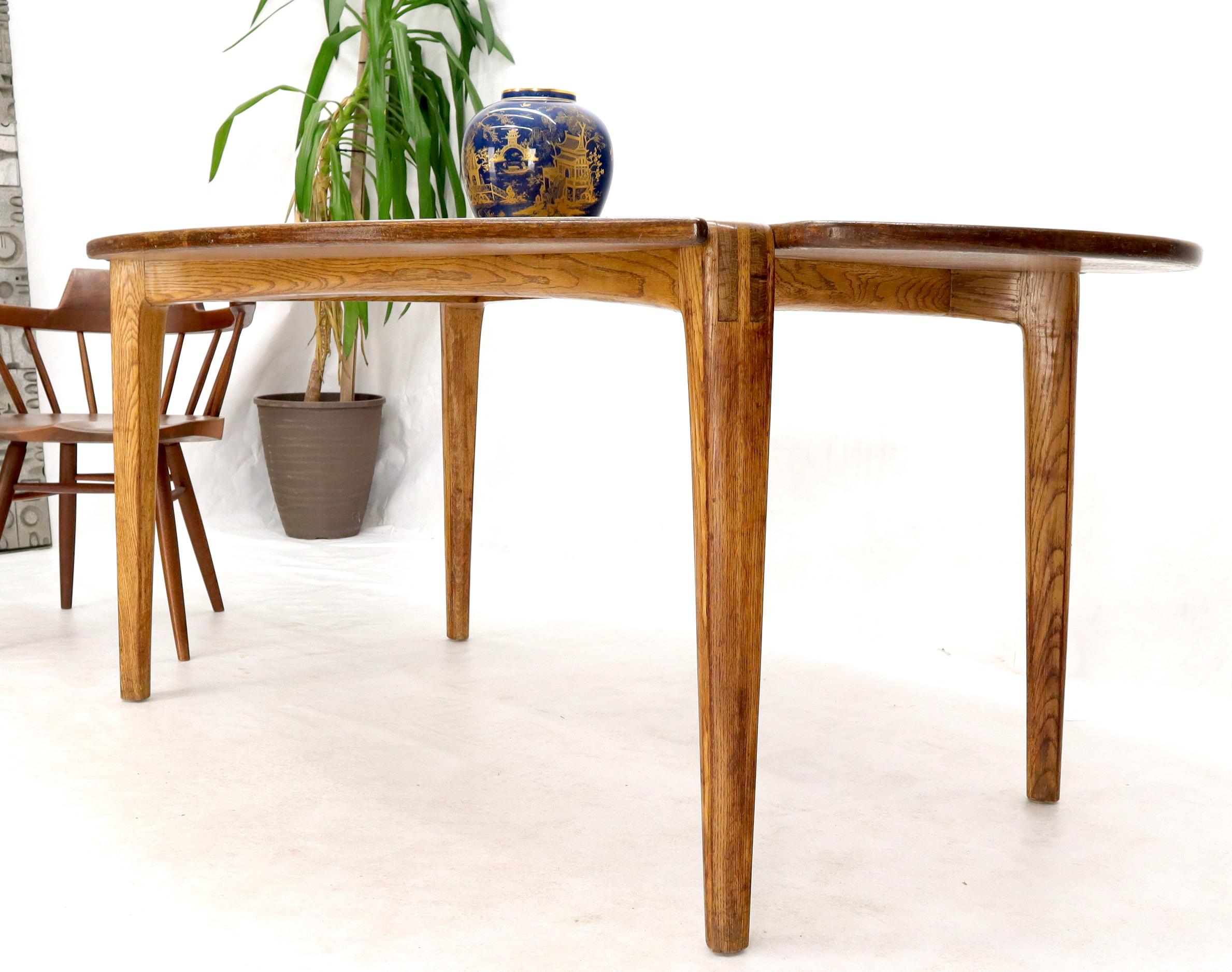 Mid-Century Modern varnished oak studio custom design oval dining table with unusual legs base concept integrating into the tabletop.