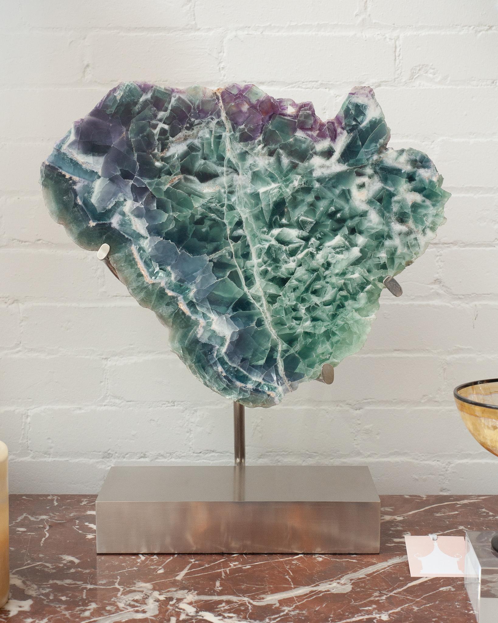 Welcome positive energy into one's interior with this massive and spectacular Studio Maison Nurita mounted fluorite slice with hand fabricated base. Made from brushed nickel-plated steel, the floating base securely holds the heavy specimen