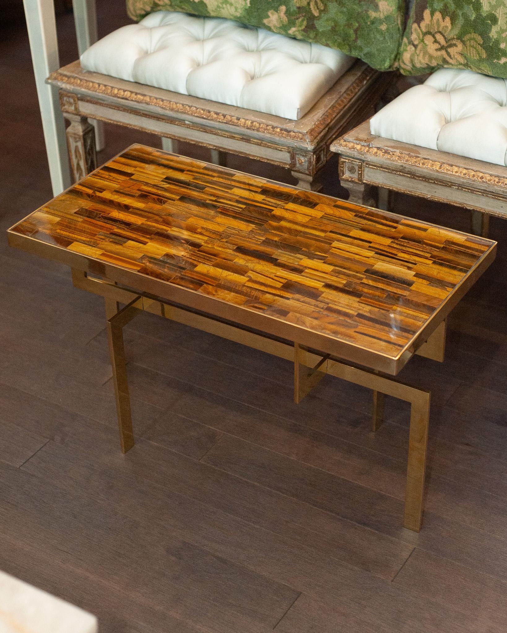 A gorgeous Studio Maison Nurita handmade brass table with asymmetric base and precious tiger's eye stone top. This beautifully made table showcases the natural beauty of tiger's eye with intricate brass creating a bezel around the stone. The play of
