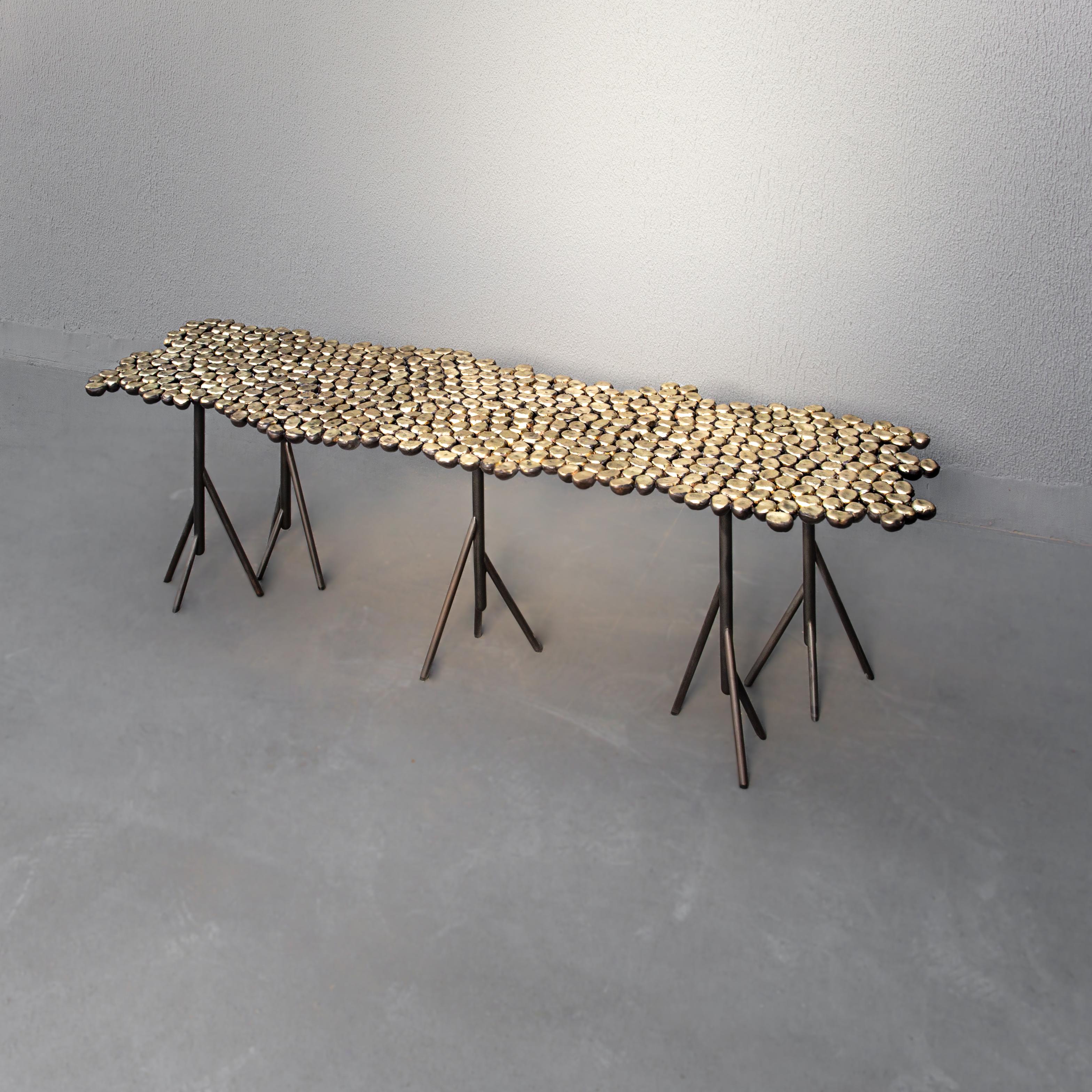 Chestnut, Georges Mohasseb Design, 2019
Chestnut is a coffee table/bench cast in brass, oxidized on the bottom (black color), and brushed on top (golden color).
Inspired by the chestnut fruit laid out flat and connected all together, the random