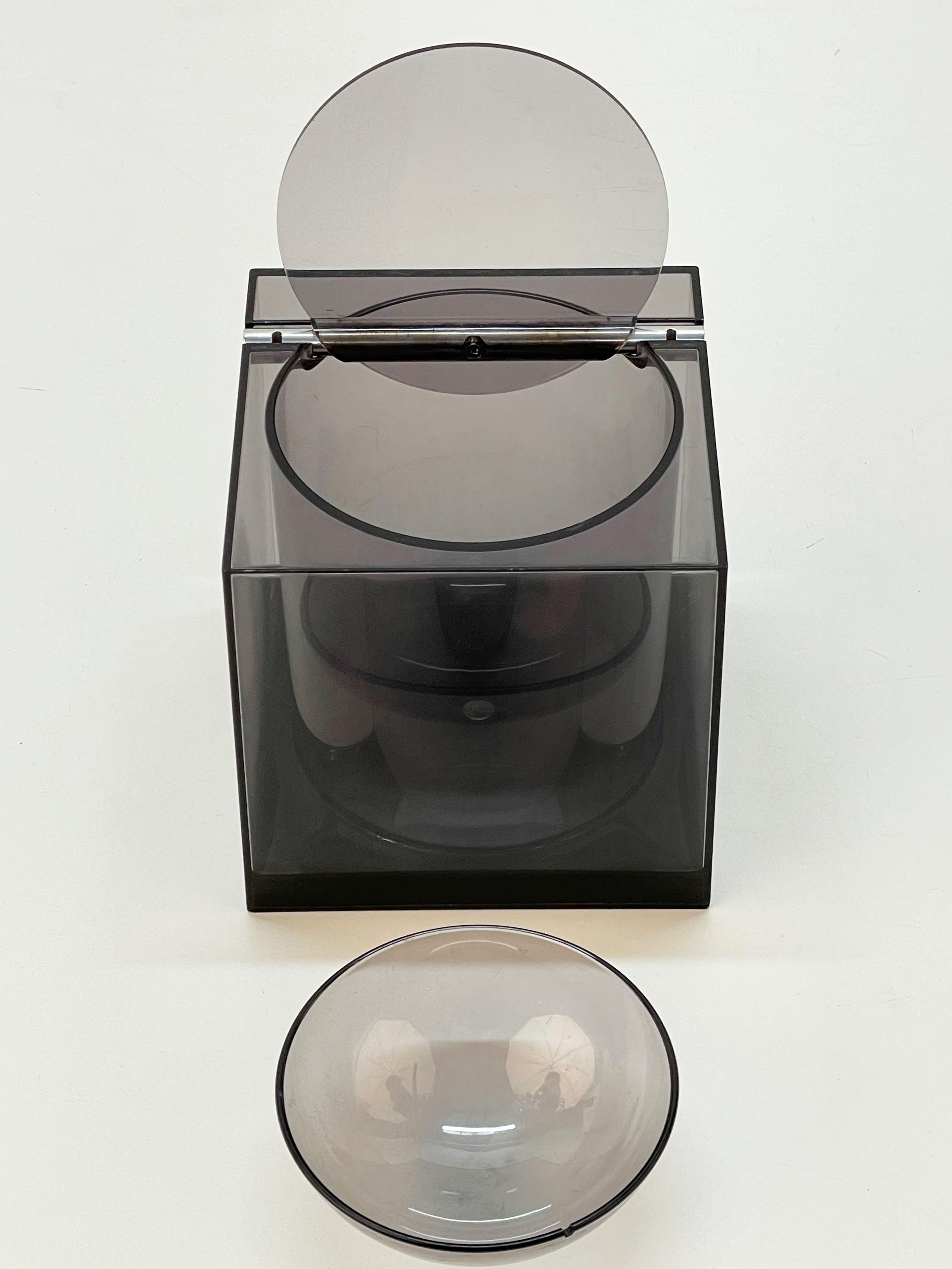Wonderful mid century smoked acrylic cubic ice bucket for Di Cini & Nils. This amazing item was designed by the Italian Studio Opi, and specifically by Franco Bettonica and Mario Melocchi, in 1974.

This serving piece is astonishing thanks to its