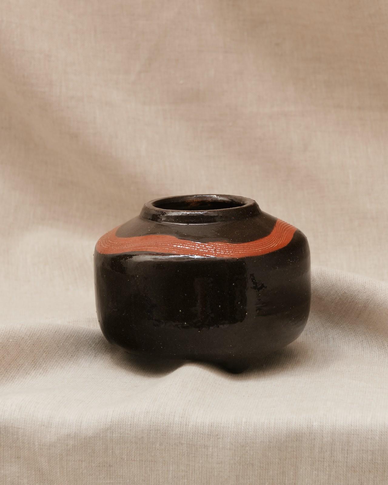 Pot à pied de Studio pottery avec une bande orange autour du bord
H14 x W11cm