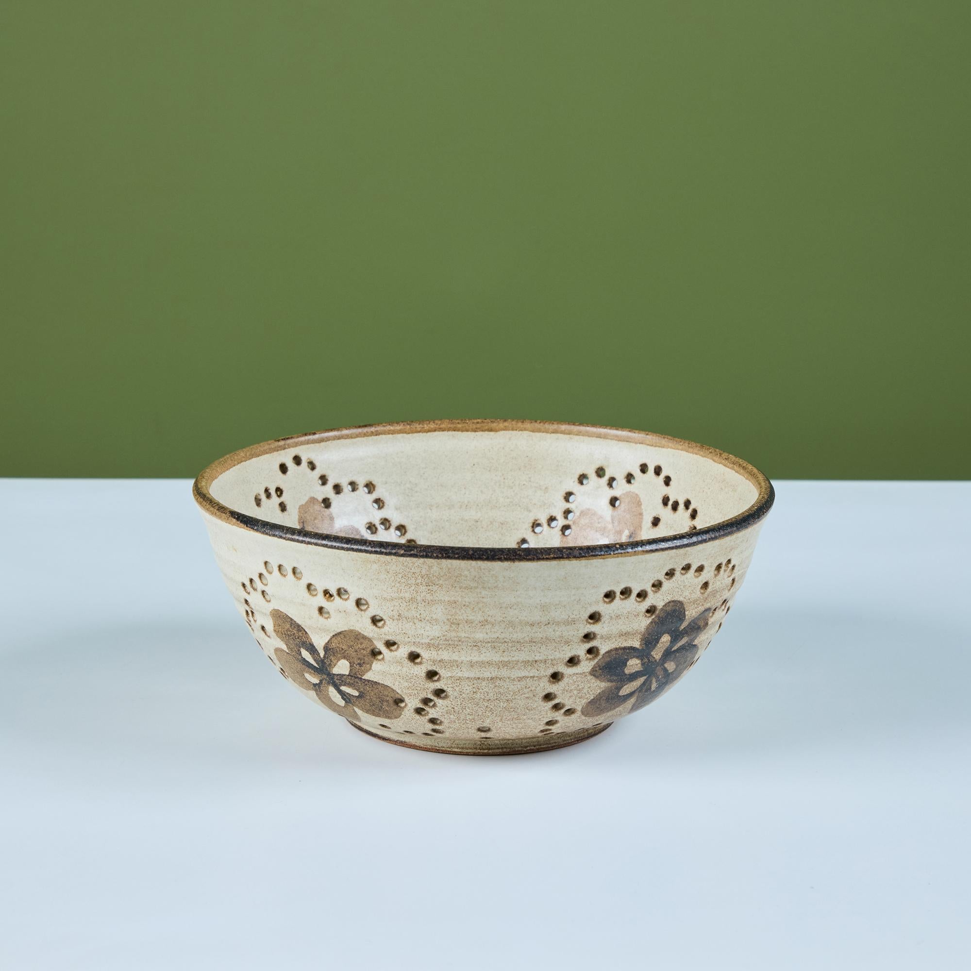 Scolapasta in gres di Studio Pottery, realizzato a mano, con smalto crema all over, bordo smaltato e motivo floreale. Sia i disegni floreali che il fondo della ciotola sono circondati da fori di drenaggio rotondi, sia per la decorazione che per