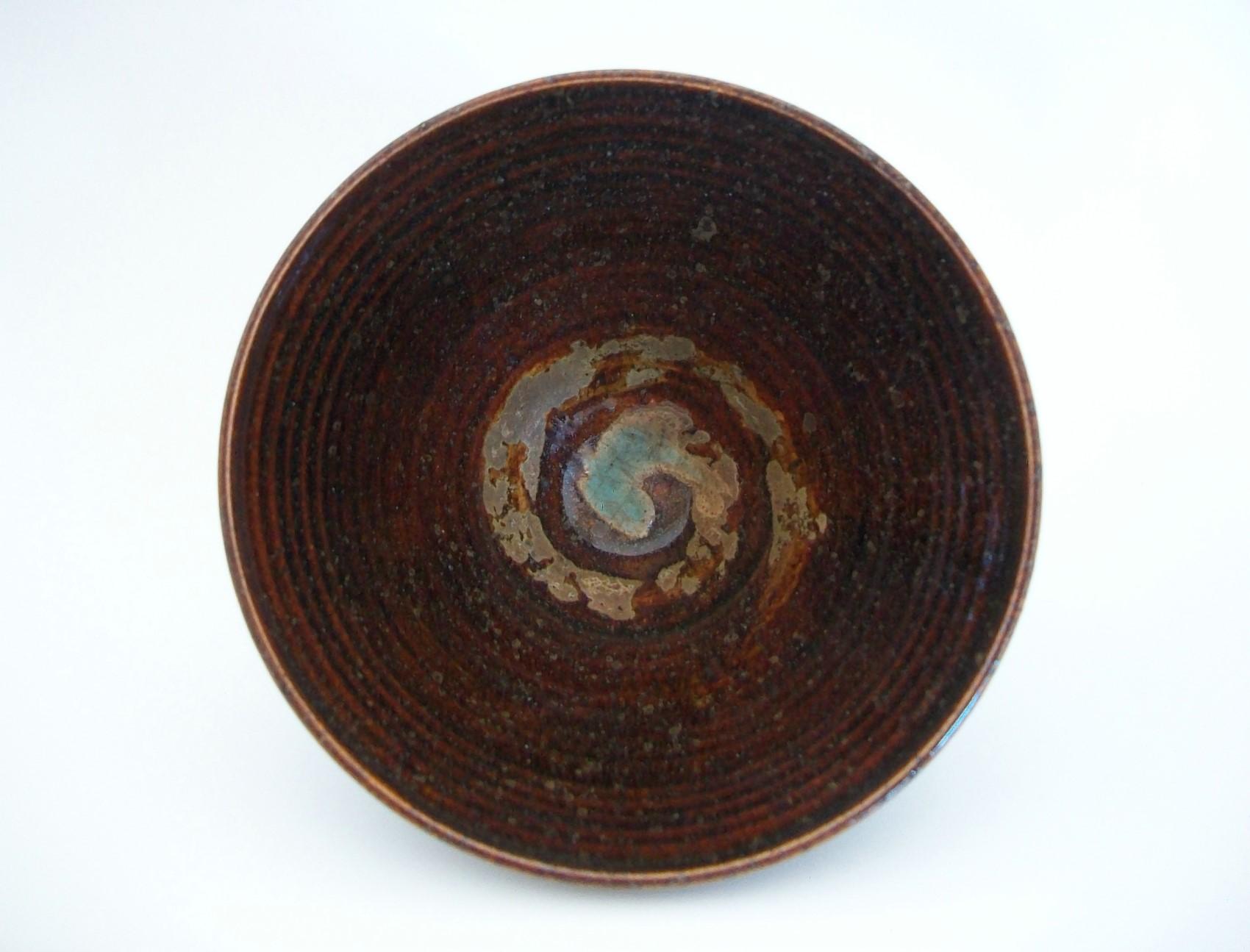 Superbe bol conique de Studio Pottery - jeté au tour avec un motif tourbillonnant peint à la main à l'intérieur du bol en tan et turquoise - glaçure brune brillante infusée de sable sur l'ensemble - indistinctement signé et daté sur la base - Canada