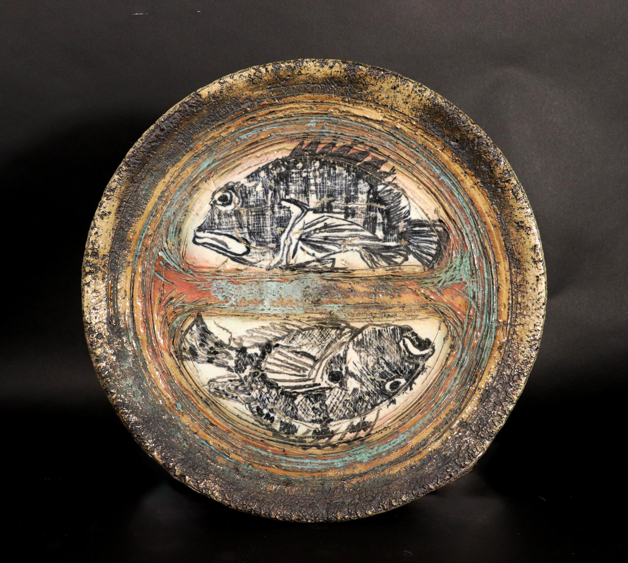 Studio Pottery Double Fish Dish,
 La Funente, Dated 2003

The large stoneware Studio Pottery dish depicts two fish within demi-lune panels. The dish was made using enamel and a sgraffito technique creating a strong rustic functional and decorative