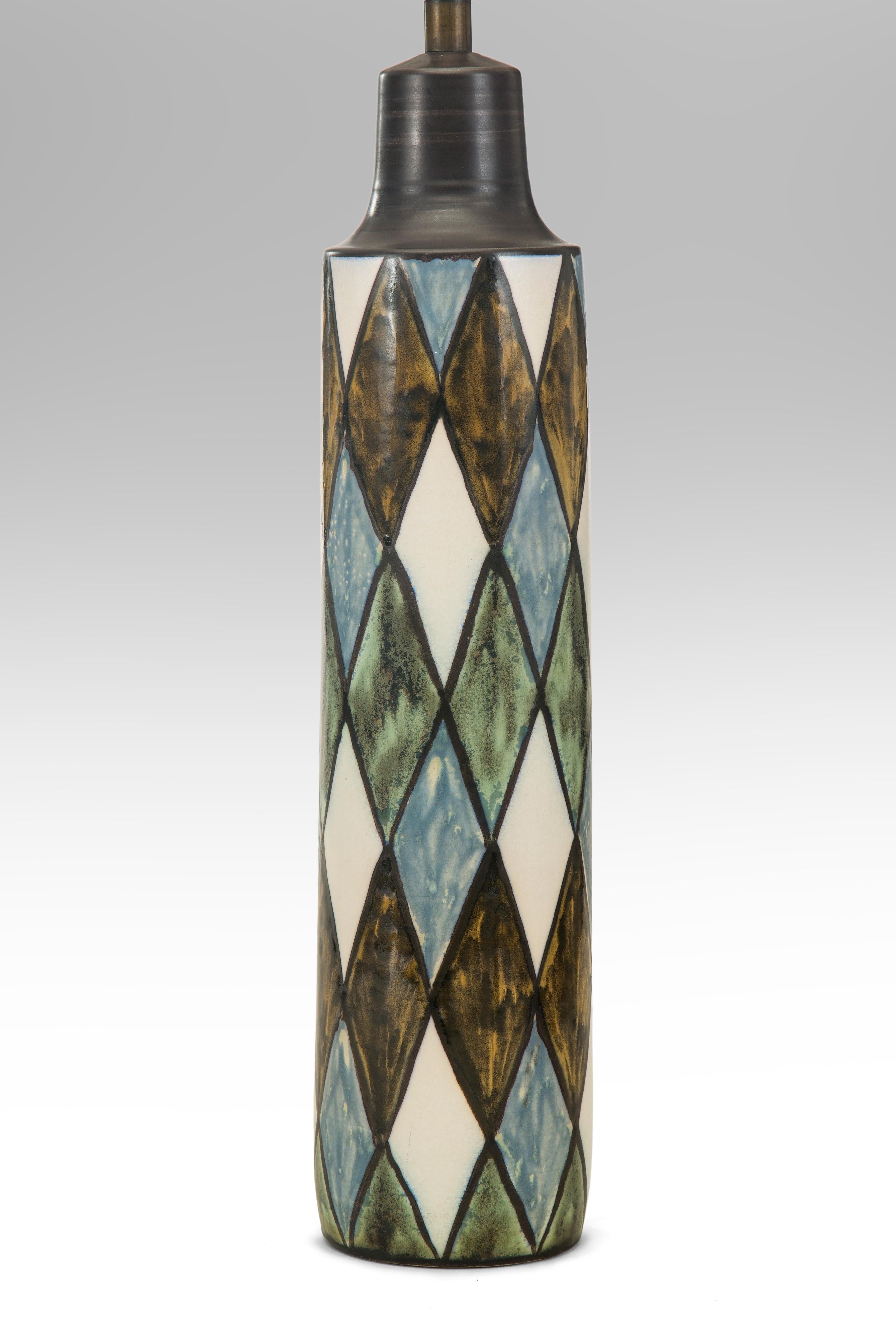 Studio Pottery Lamp, Signed Lotte
Mid-20th century
The harlequin pattern has endured because it is an expression of both sophistication and joy. The columnar lamp glazed in a striking harlequin design of blue, green, brown and white. This is a