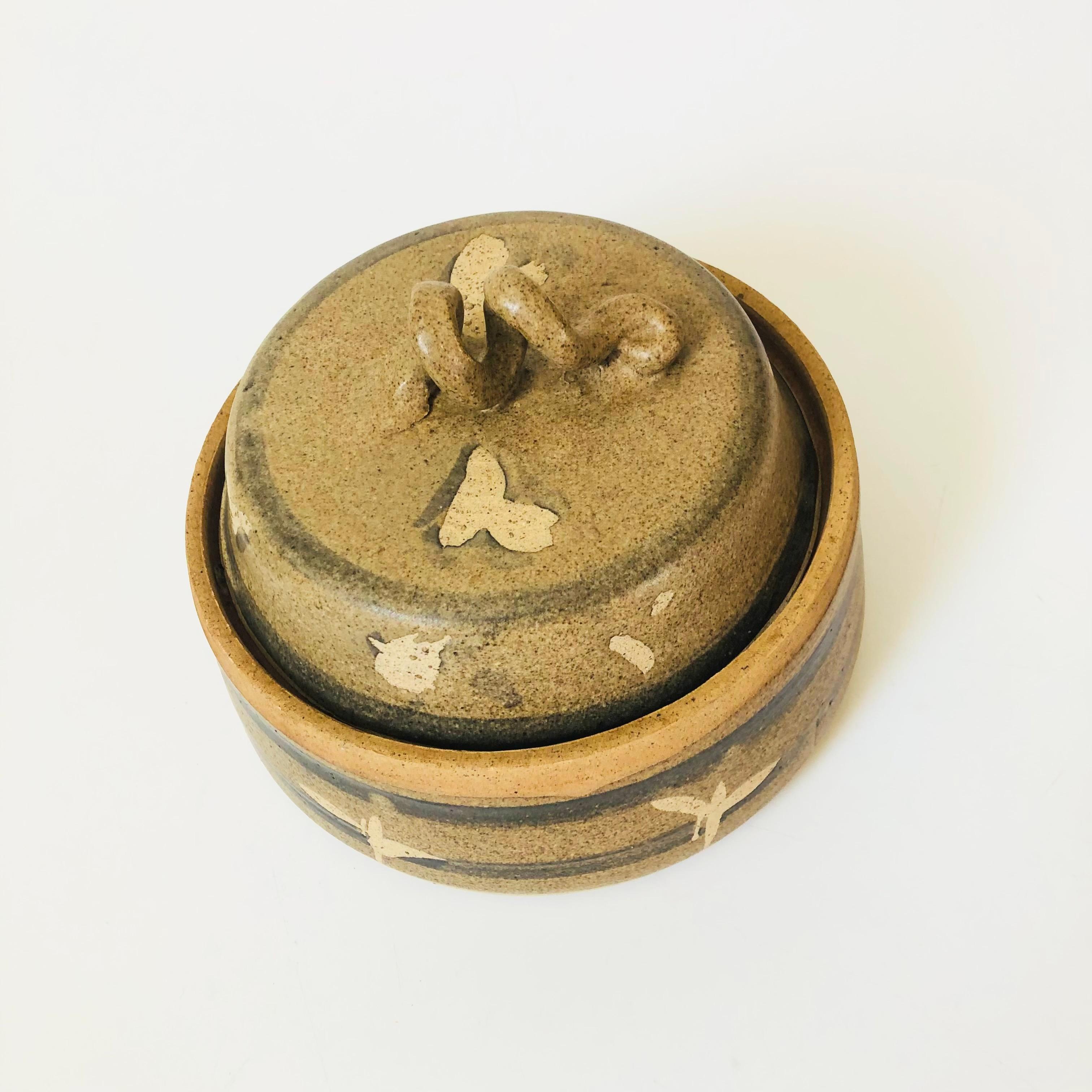 A beautiful vintage studio pottery lidded serving bowl. Earth tone glazes and a unique cork screw shaped handle. Nice size, perfect for serving a variety of dishes. Signed on the base by the maker.

