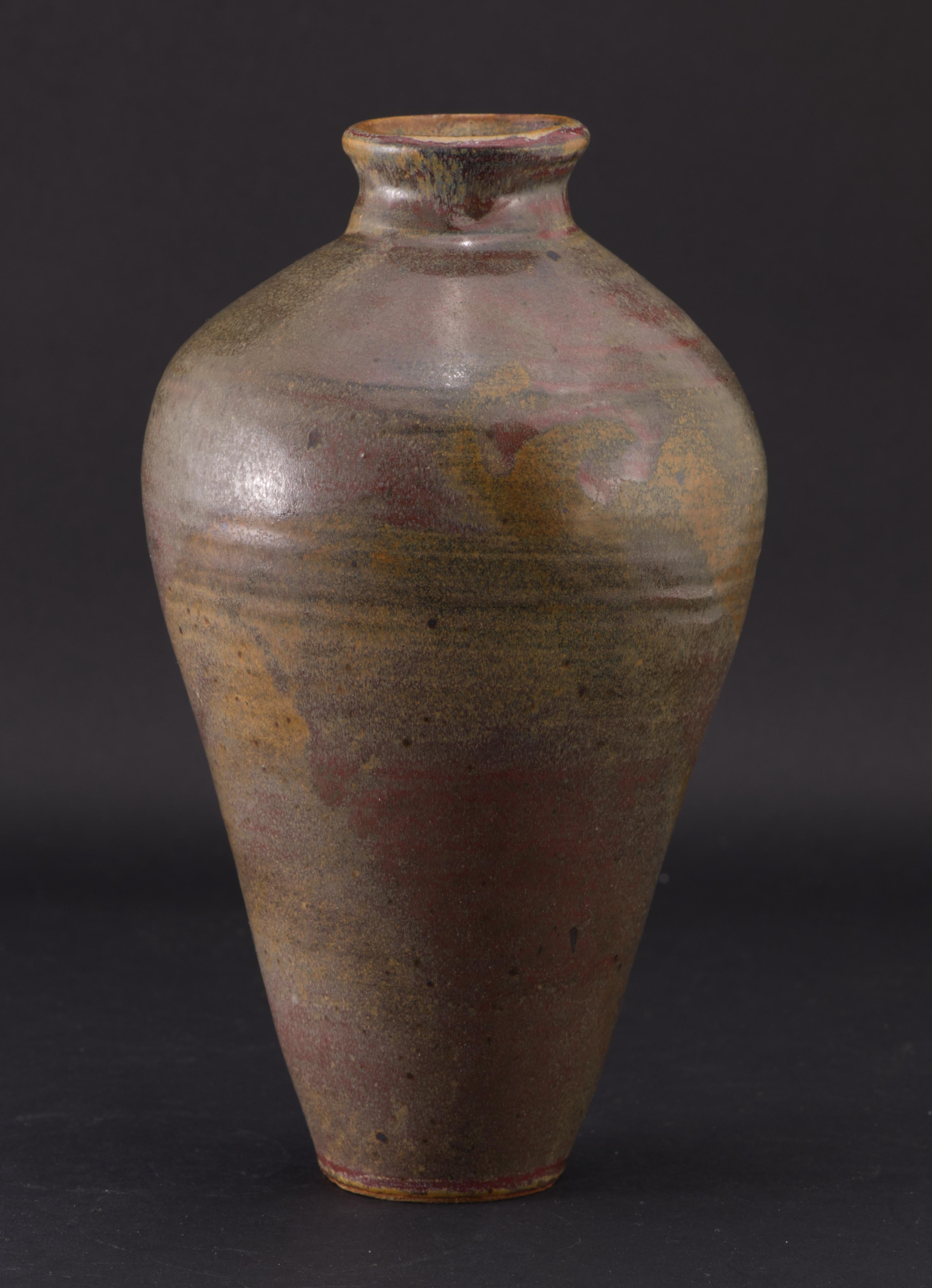  Beautiful hand thrown vase in classic amphora shape has narrow base and opening, contrasting with the wide body. The opening rim and curvature of the upper portion of the body are slightly asymmetrical, exemplifying the appeal of hand-made piece.