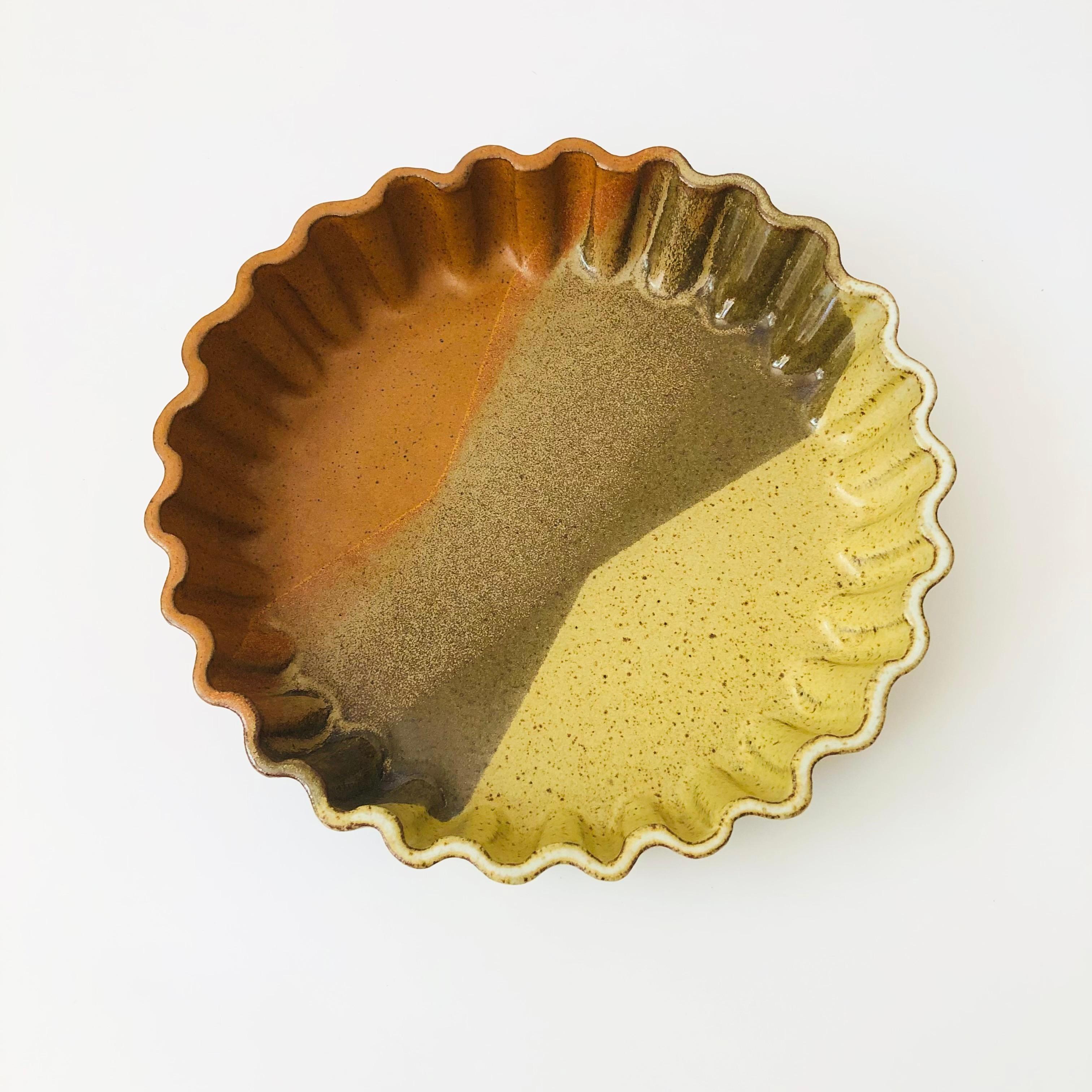 Un grand plat à quiche vintage en poterie de studio. Magnifiques glaçures superposées de couleur terre et bordures festonnées. La lettre G est estampillée sur la base. Parfait pour la cuisson de quiches ou comme plat de service.

