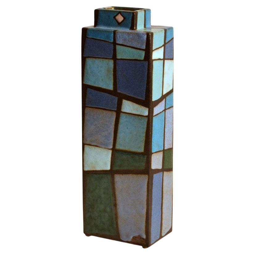 Decorative rectangular studio pottery vase with a pattern in multi tones of blue and turquoise applied in blocks of color on nearly black earthenware, signed Swano.