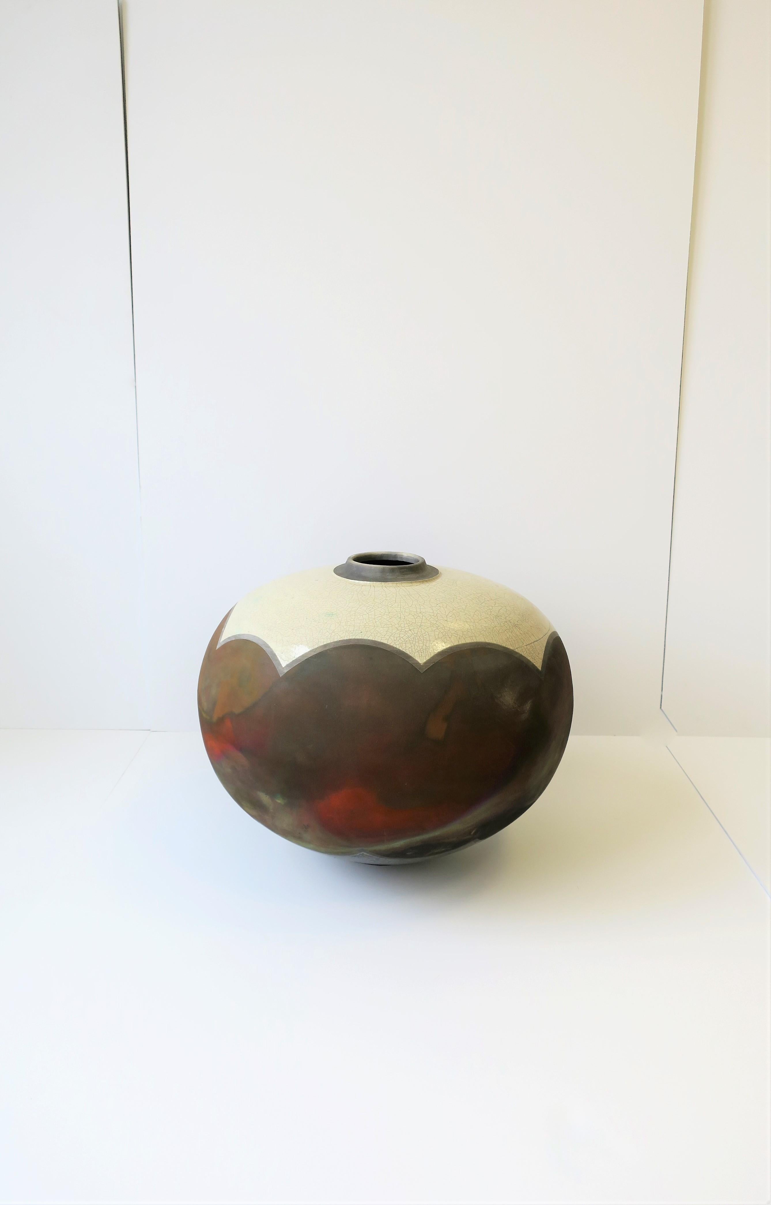 A beautiful, relatively large, round studio pottery vessel or vase, circa 1960s-1970s. Vessel is part glazed and unglazed with 'crackle' at top, matte texture at centre with vibrant colors, and iridescence at base. This beautiful combination is