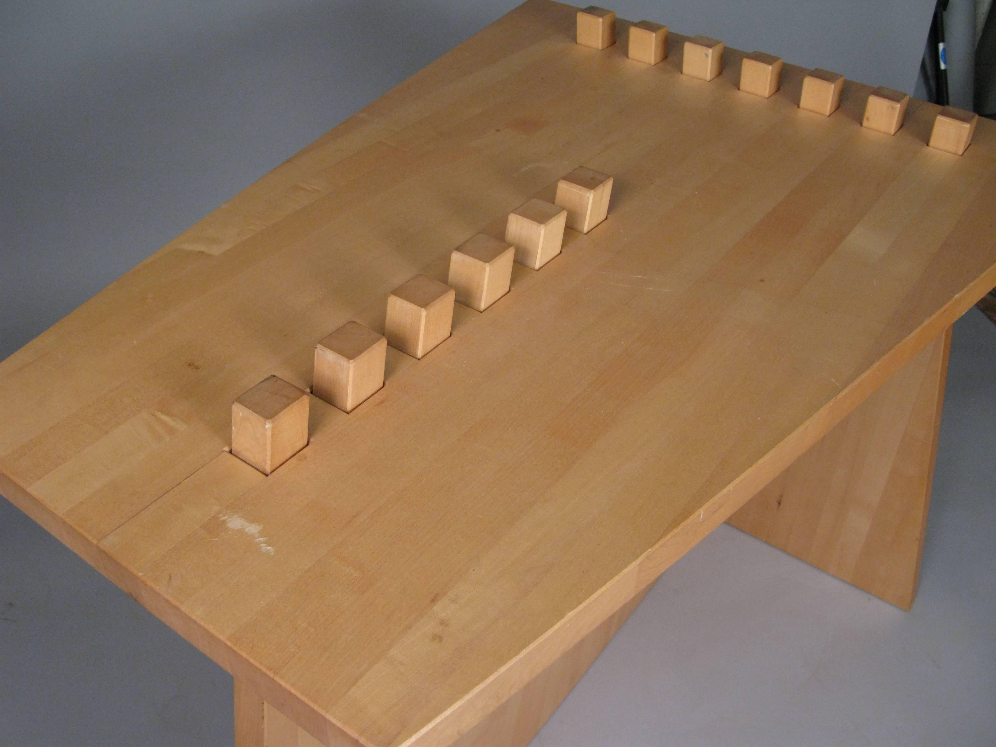 A very interesting studio craft 'puzzle' table in light oak. of unknown origin, it is composed of three pieces which fit together, with raised tips in two rows that extend through the top.