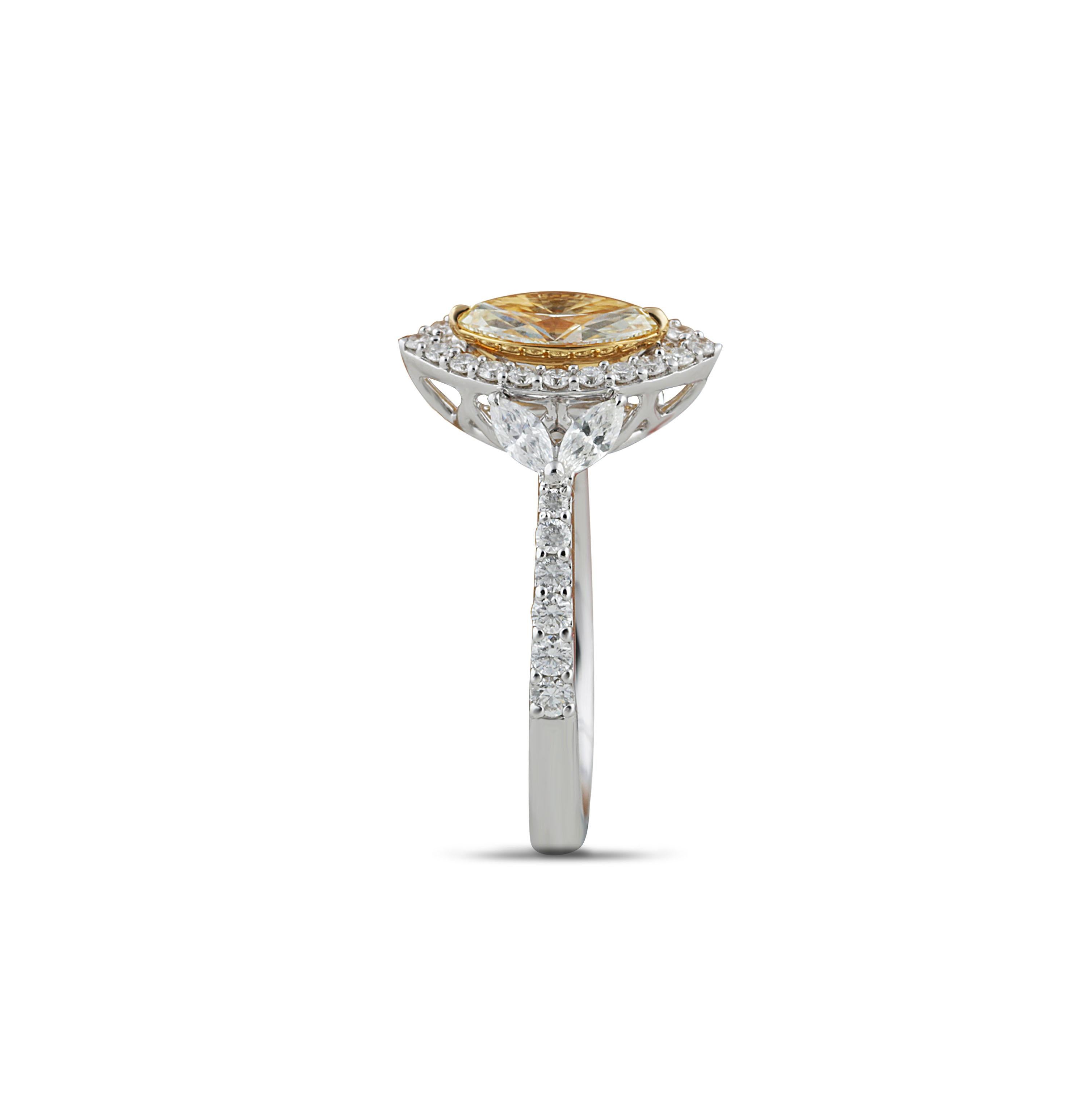 Yellow and white diamond ring

A marquise-shaped yellow diamond is closely encased by round brilliant white diamonds in a prong setting on an 18K white and yellow gold base, with white marquises on shoulders, giving it a classic look. Adorned with