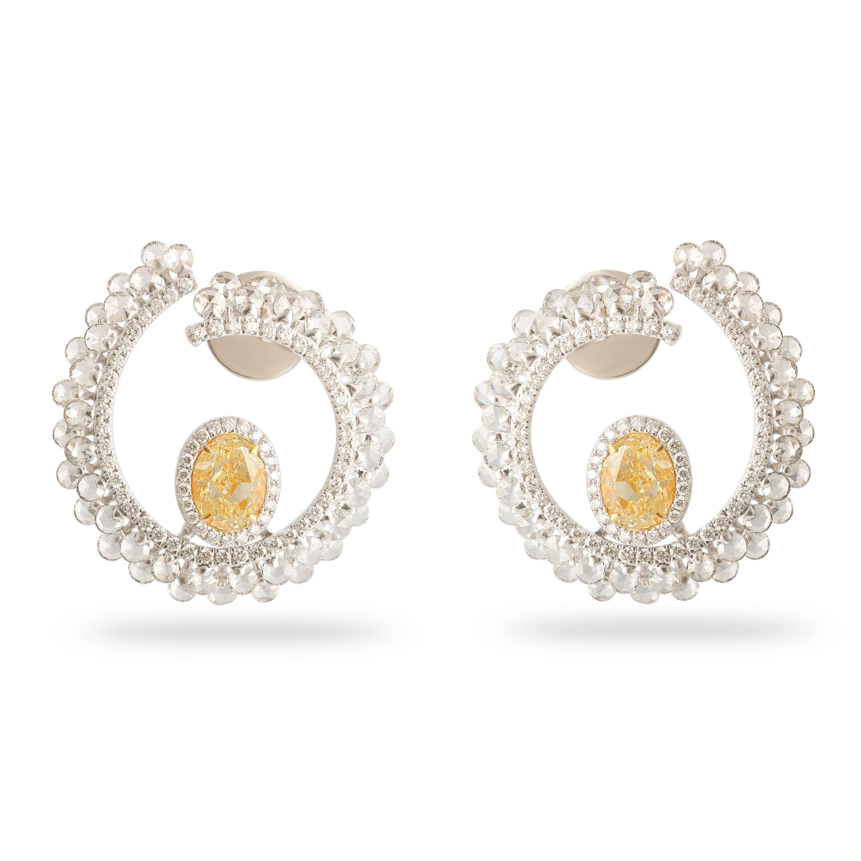 Come raggi di sole catturati in un delicato abbraccio, questi orecchini a cerchio in oro giallo 18 carati di Studio Rêves sussurrano eleganza ad ogni scintillio. Il loro cuore brilla di un paio di sogni d'oro: diamanti gialli, per un totale di 1,90