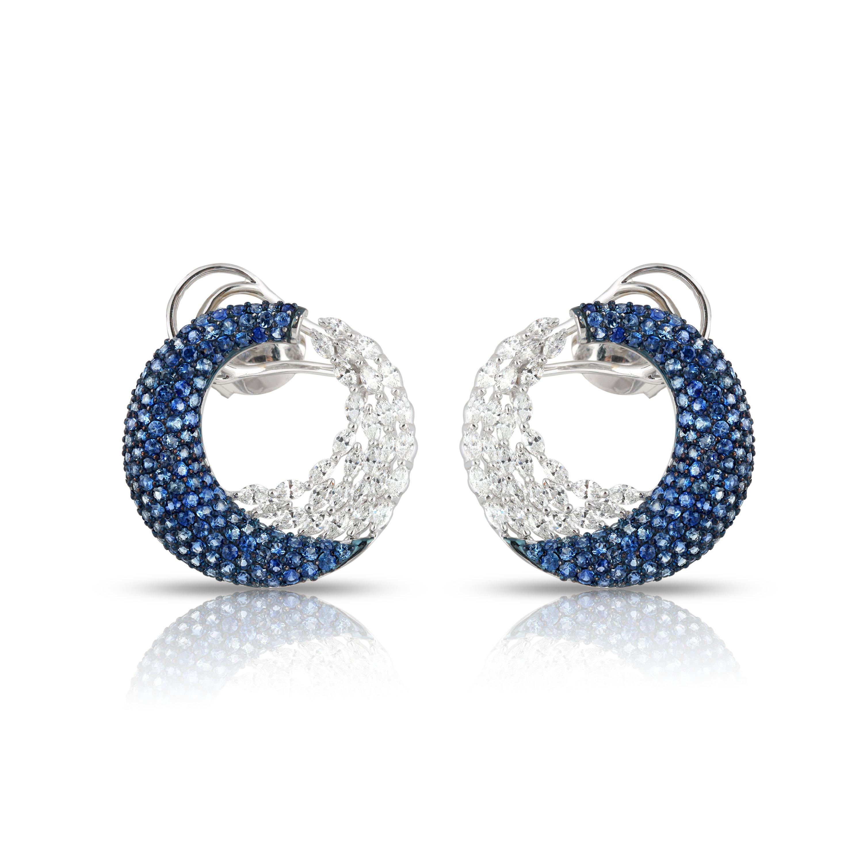 It is the ingenious amalgamation of meticulously selected brilliant cut marquise diamonds and blue sapphires that gives these broad hoops its aura of unique artistry. The 320 stones have been used in a combination of pavé and prong settings in an