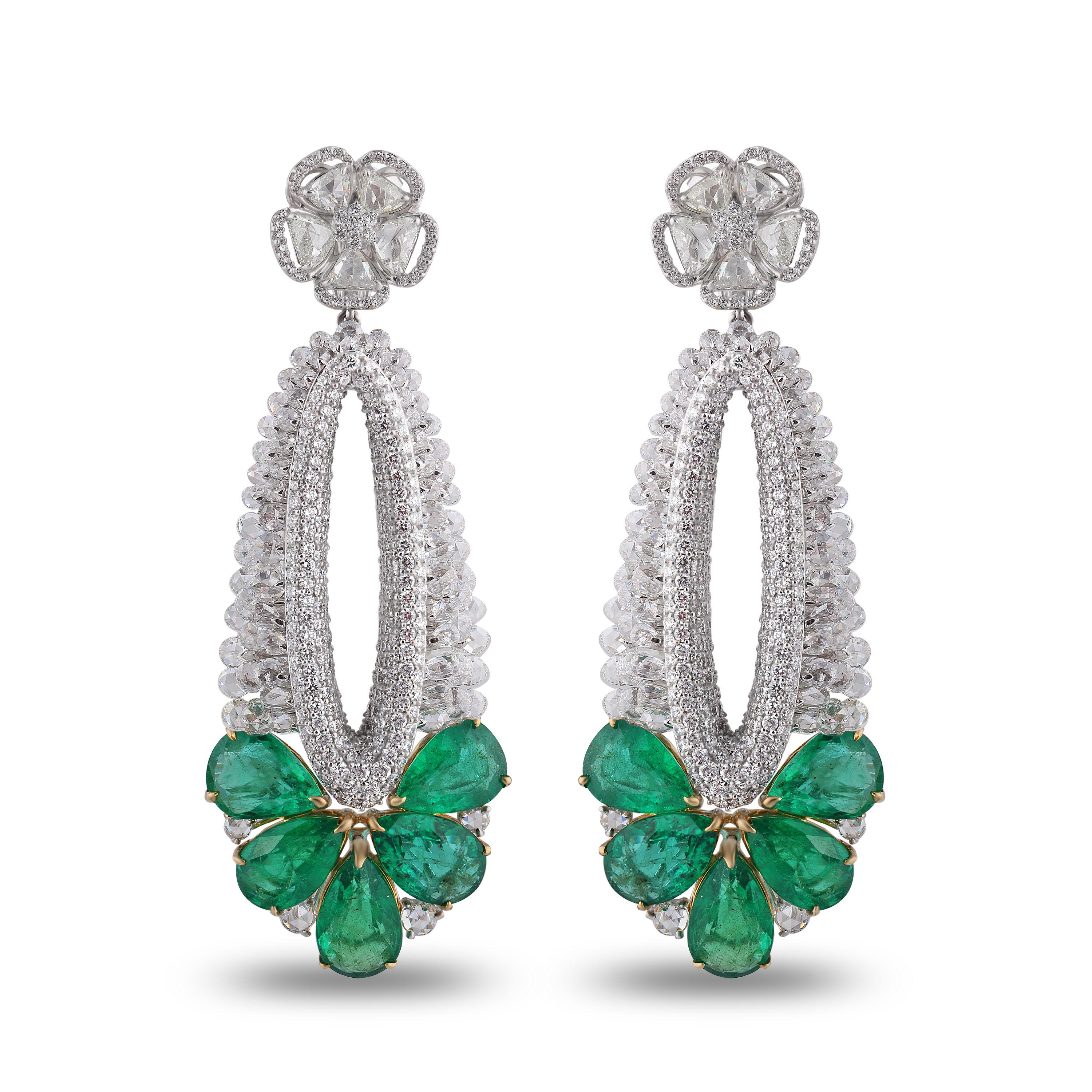 The contrast of the vivid emeralds with luminous rose cut diamonds and brilliant cut diamonds lend these danglers a glorious afterglow. The earrings are made in 18K white gold base with handpicked diamonds and emeralds in a blend of pavé, prong and