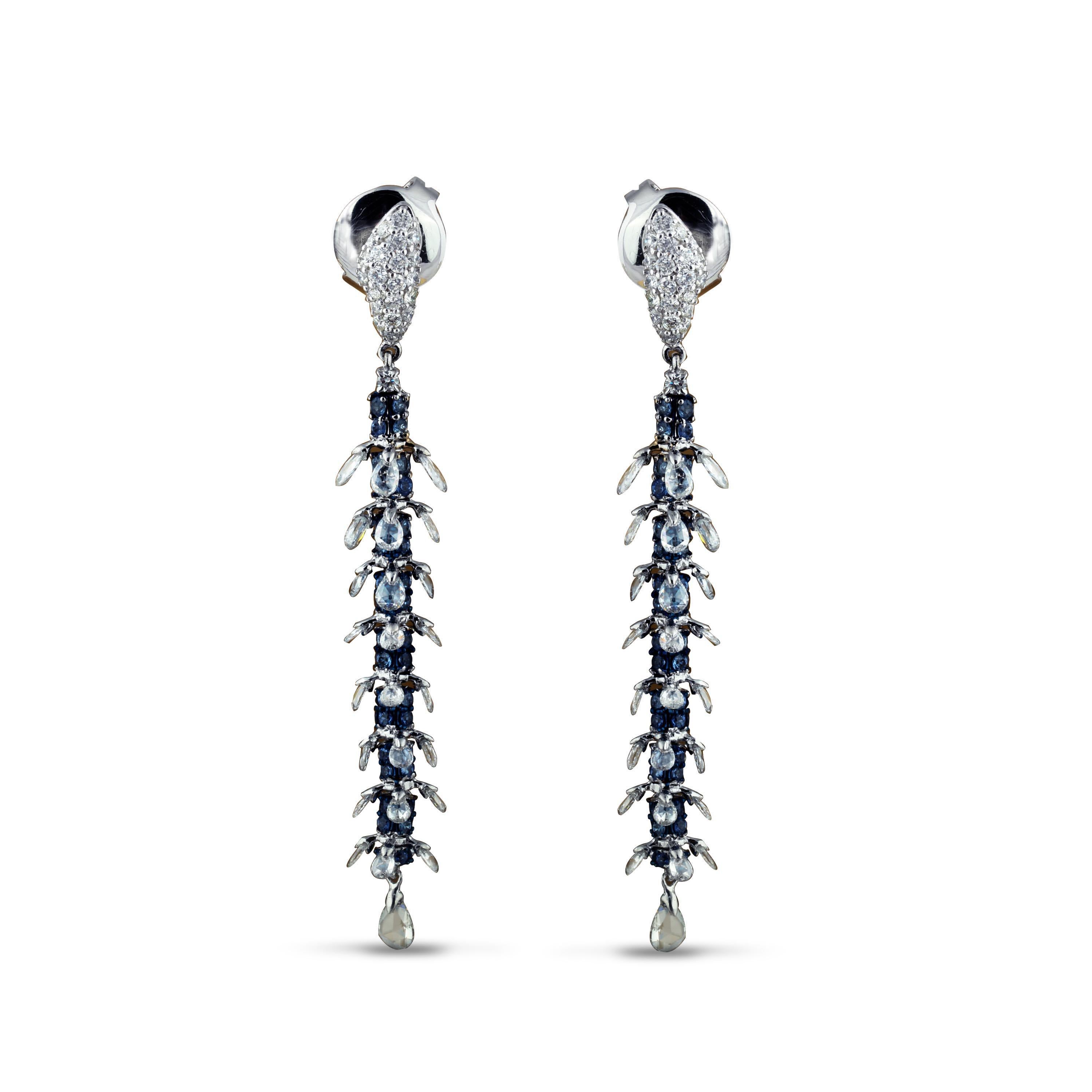 Sleek, elegant and effortless are sentiments that fittingly capture the essence of this pair of 18K white gold danglers adorned with blue sapphires and flanked by brilliant cut and rosecut diamonds. Set in a stylish mix of pavé and drill settings,