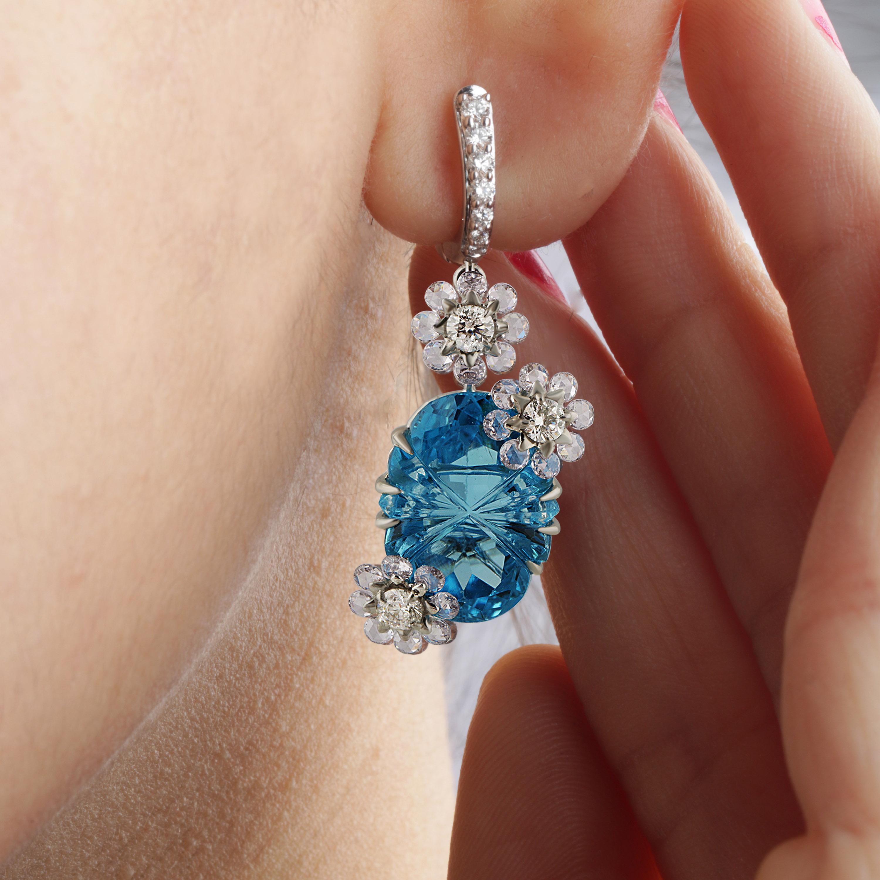 Gross Weight: 11.21 Grams
Diamond Weight: 2.03 cts
Blue Topaz Weight: 22.77 cts
IGI Certification can be done on request

Video of the product can be shared upon request.

This pair of 18K white gold earrings adorned with round cut diamonds, round