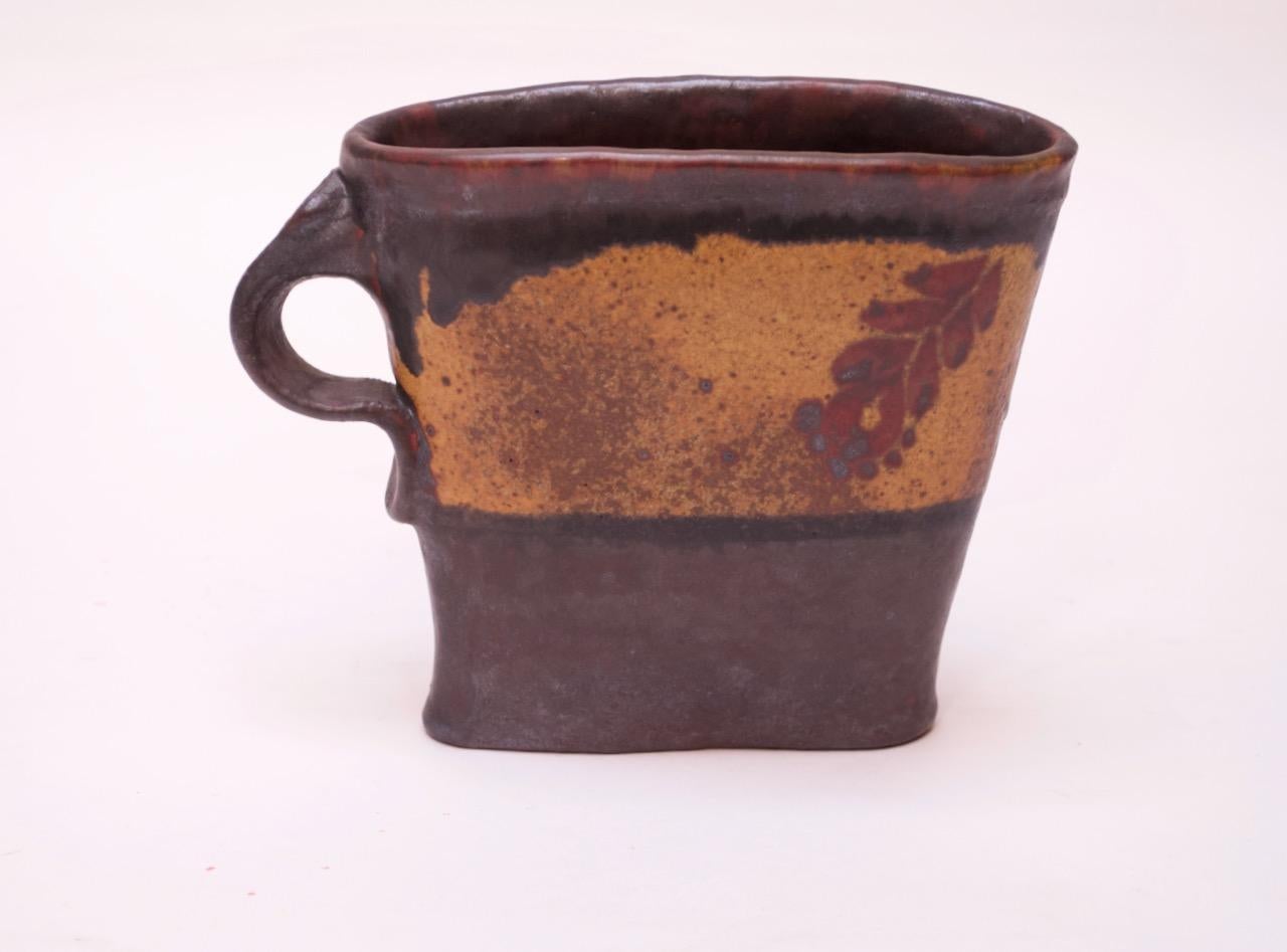 1970s Pollack stoneware pitcher / vase in an attractive autumn palette rich with brown, ochre, and red. Crude by design in regards to its asymmetric shape. 
Incised 