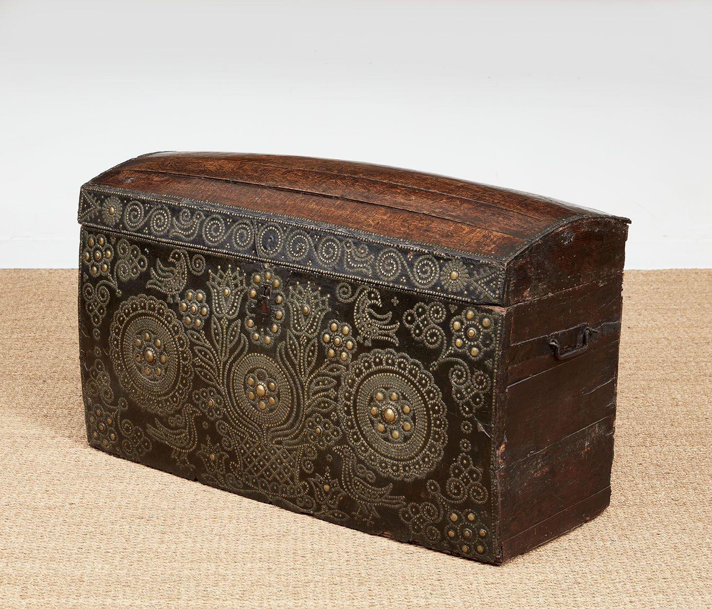 A studwork leather fronted and oak domed travel chest or trunk, with the front decorated with birds and a basket of flowers flanked by two decorative roundels outlined in brass studs on a leather ground.  The top with nicely patinated oak boards. 