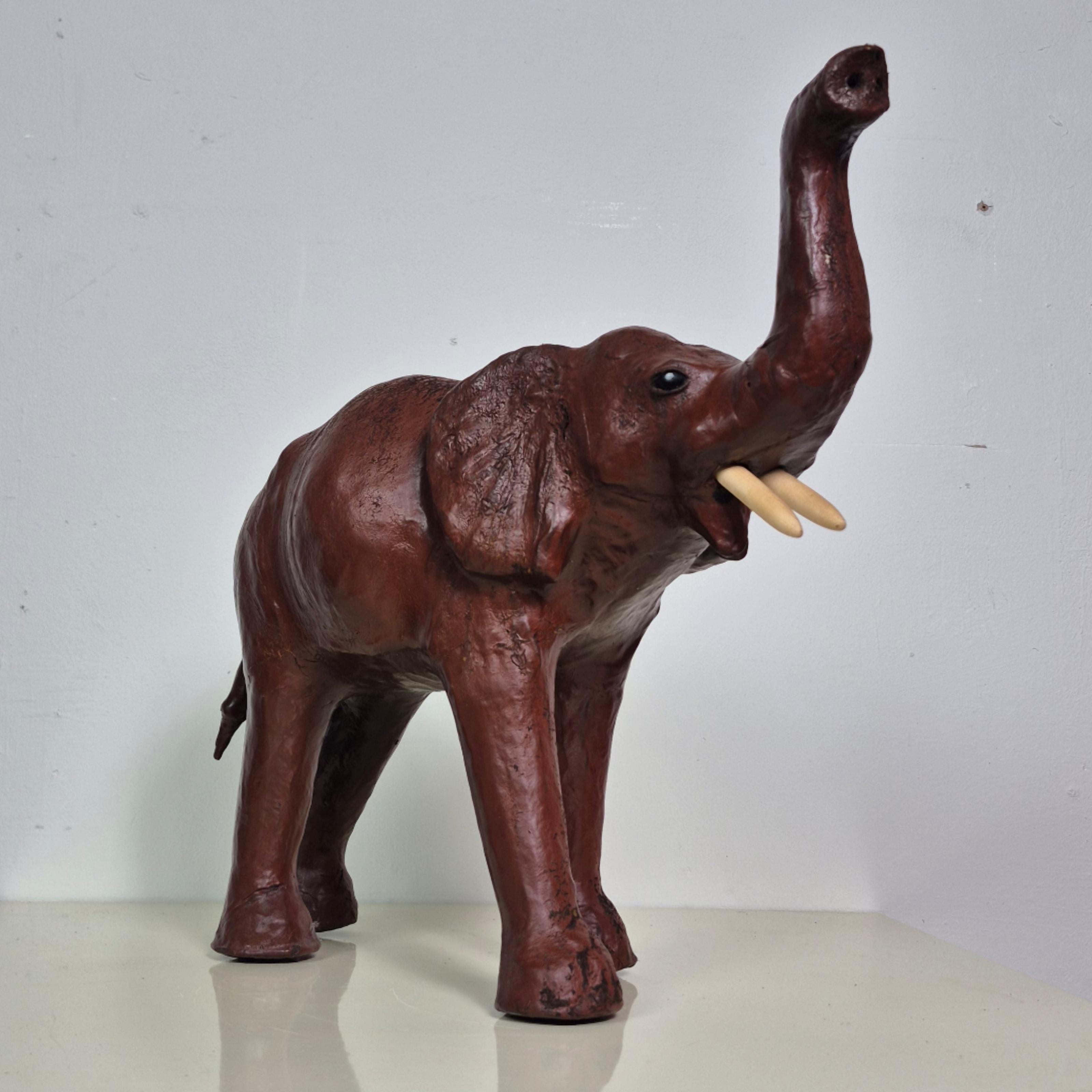 Mid century elephant figure. Made from straw covered in leather. Beautifully hand crafted piece with lots of character. The stance of the elephant is powerful with its trunk up in the air. Great decorative object. 

Originally it had tusks made of