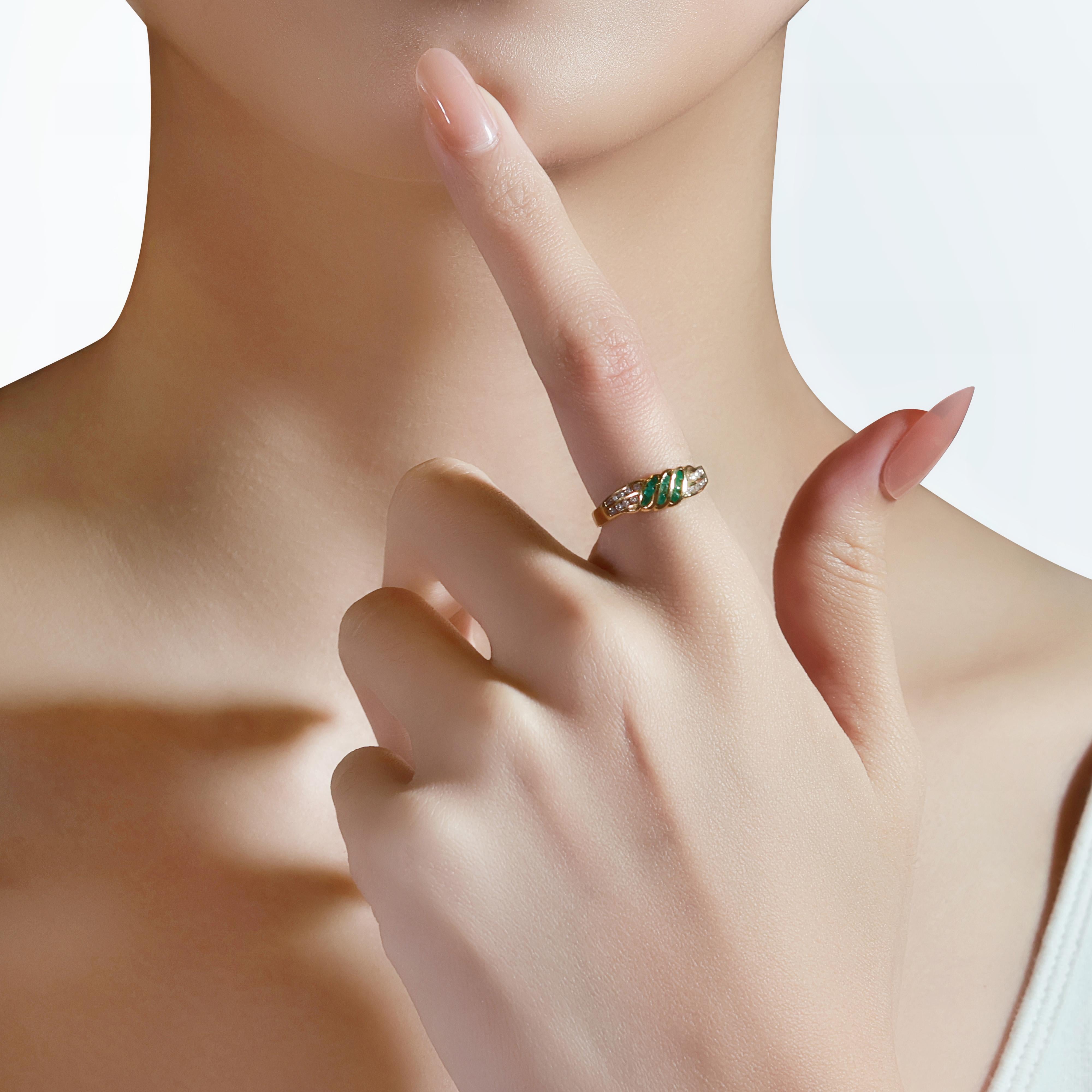 Cette superbe bague en or jaune 18 carats est ornée de 9 émeraudes rondes taillées en brillant, totalisant 0,19 carats, offrant une teinte verte vibrante. La pièce est magnifiquement complétée par 18 diamants ronds de taille brillant totalisant 0,07