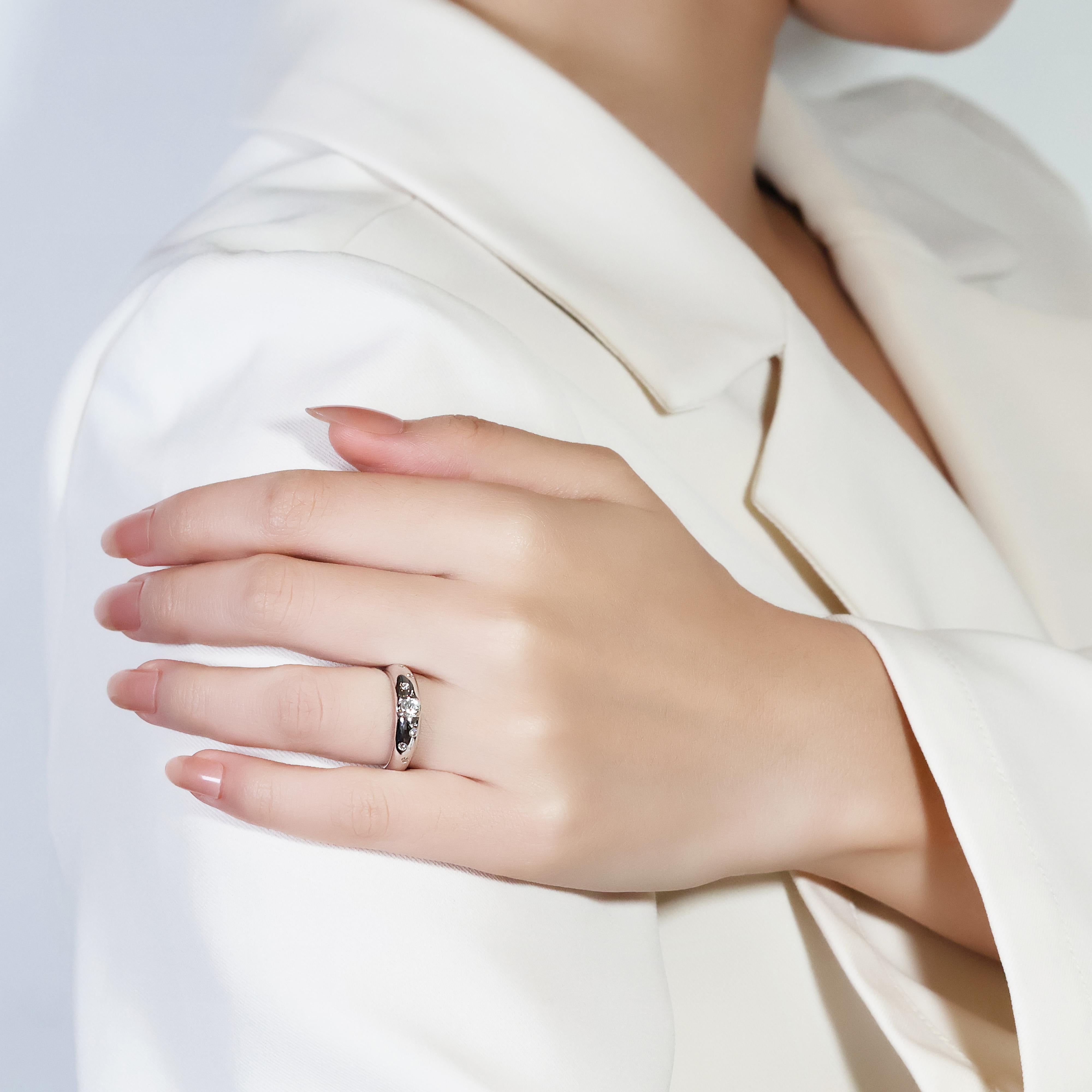 This exquisite 18k white gold ring boasts a dazzling 0.22ct round brilliant cut diamond, graded G in color and VS in clarity, as its centerpiece. Enhancing its brilliance are six additional round brilliant cut diamonds, each weighing 0.09ct, also