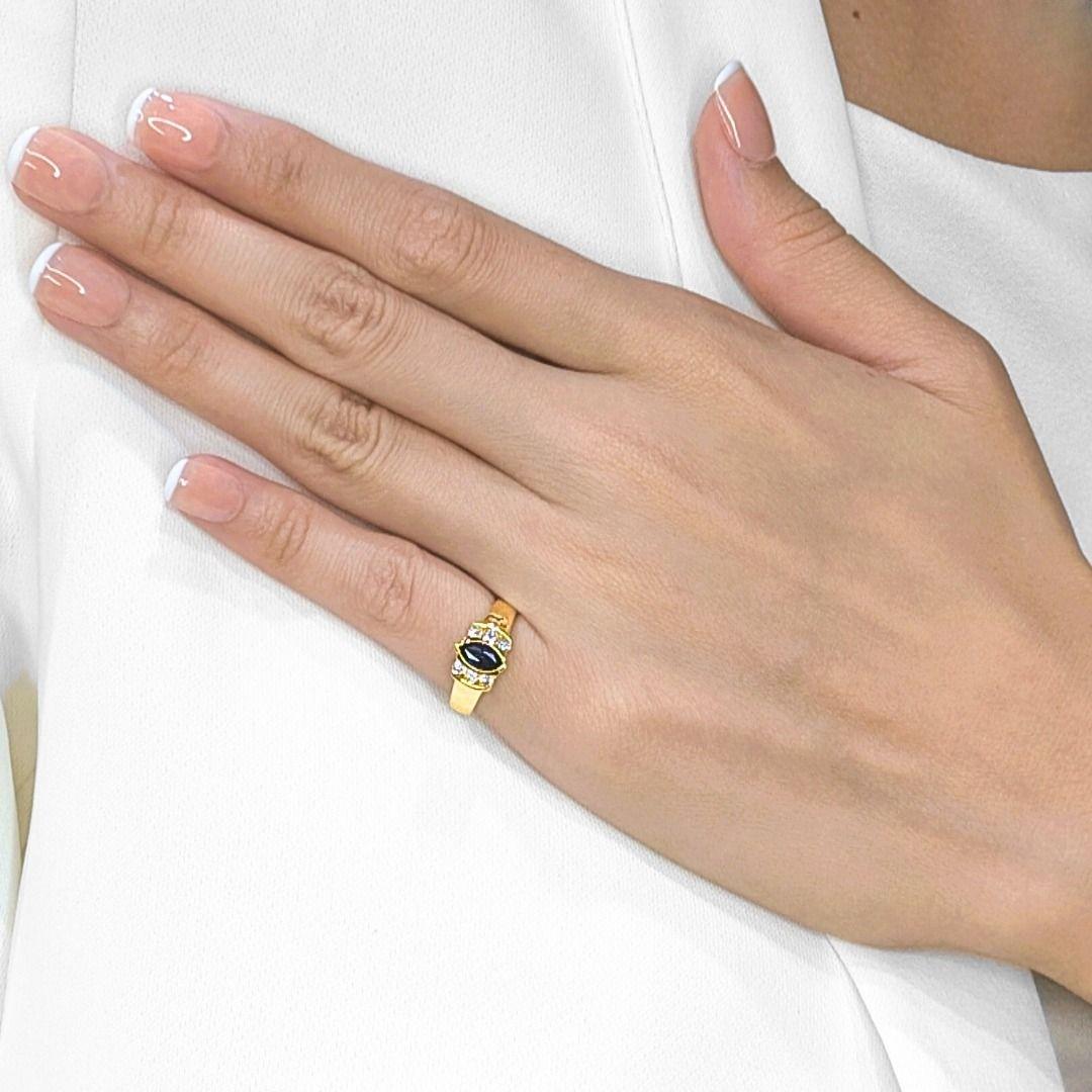 Cette élégante bague fait preuve d'une sophistication intemporelle, avec en son centre un saphir bleu foncé taille marquise de 0,19ct, d'une profondeur et d'une allure remarquables. Le saphir est entouré de six diamants naturels ronds et étincelants