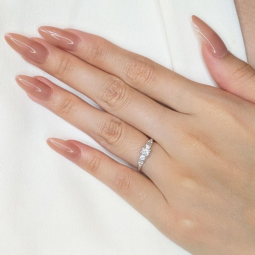 Adorned with a dazzling 0.25ct princess-cut natural diamond (G color, VS clarity) as the centerpiece, this 18K white gold ring exudes timeless elegance. It features four additional natural diamonds—two round brilliant and two pear-shaped—adding up