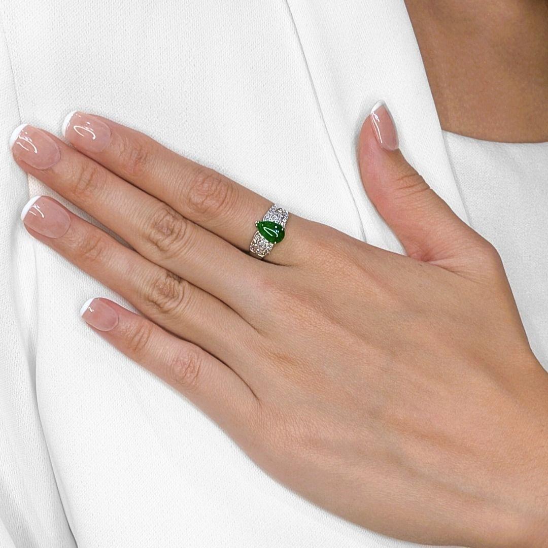 Questo raffinato anello emana una raffinatezza senza tempo grazie a una giada a forma di pera da 0,48 carati che risplende in un lussureggiante verde naturale. La gemma centrale è impreziosita da 24 scintillanti diamanti tondi brillanti (0,12