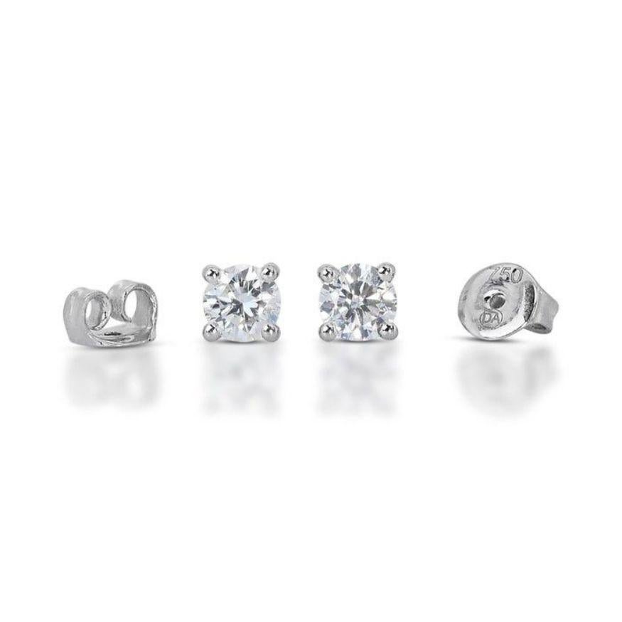 More than just earrings, these exquisite pieces are a whispered promise of unwavering confidence, written in 0.95 carats of captivating fire. Two 0.475-carat round brilliant diamonds, boasting refined H-I color and near-flawless VS2 clarity, take