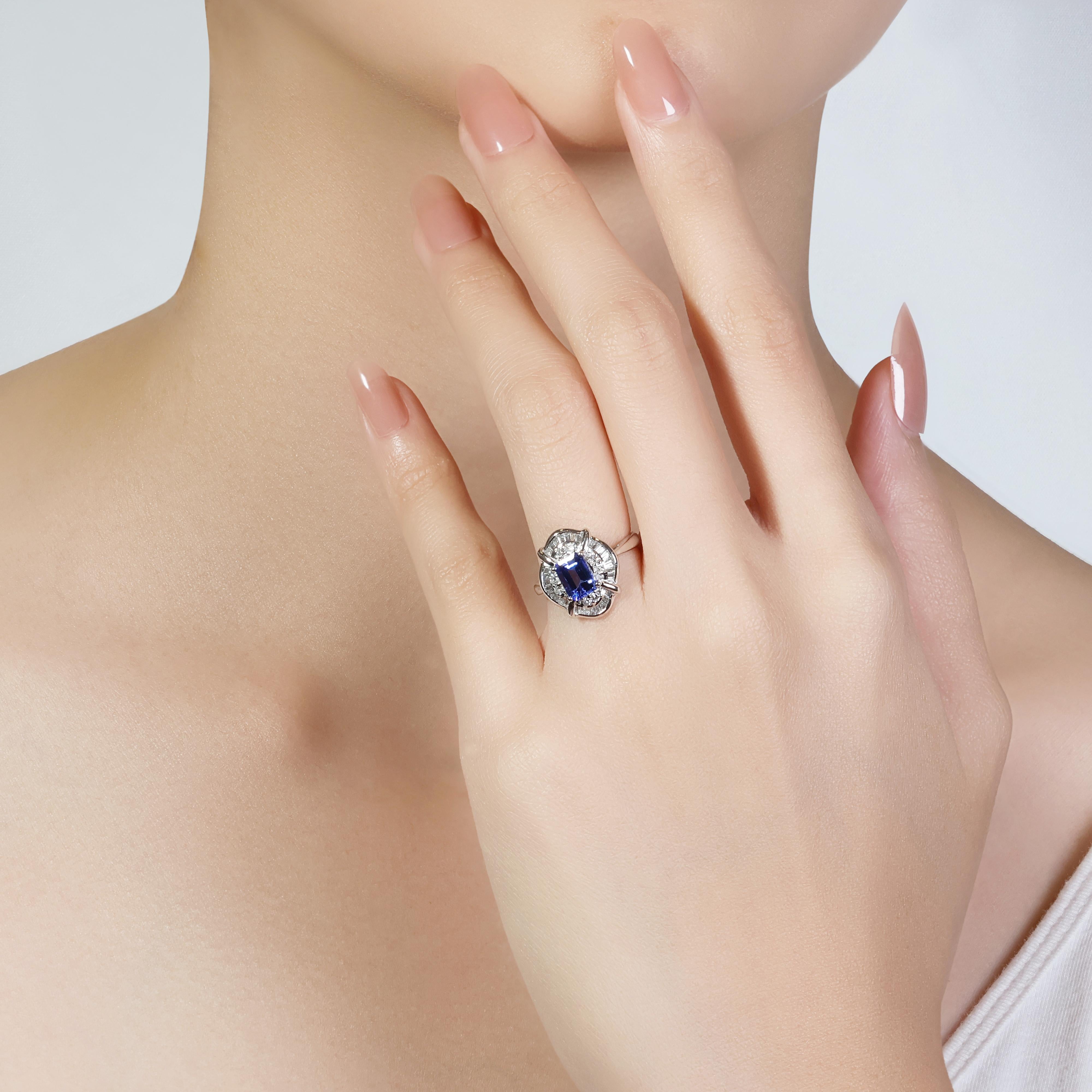 This exquisite platinum double halo ring is a masterpiece of luxury and elegance. Showcasing a stunning 1.03ct emerald-cut tanzanite as its centerpiece, the ring's brilliance is amplified by a double halo of 8 round brilliant diamonds totaling