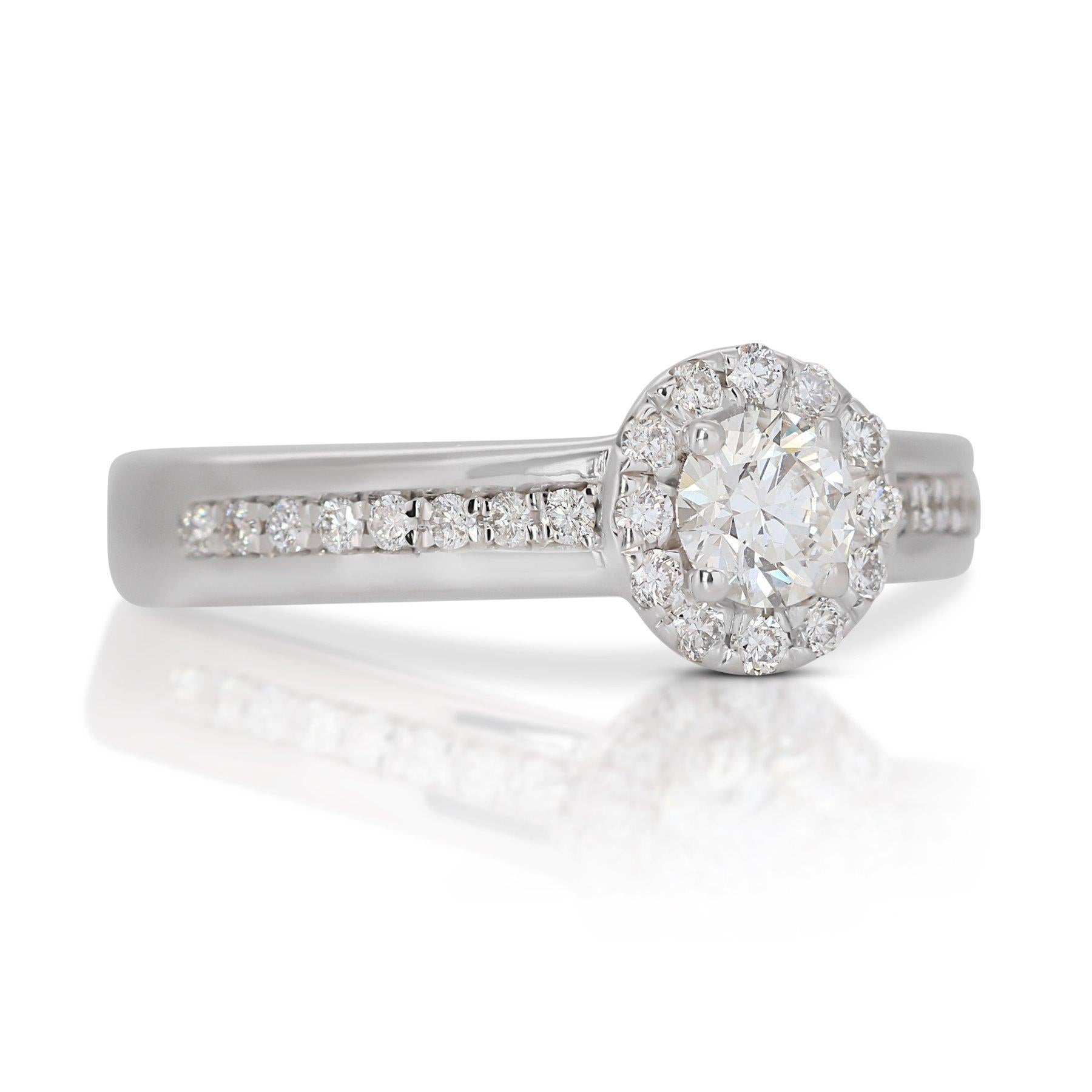 Stunning 1.00ct Triple Excellent Ideal Cut Diamond Halo Ring in 18k White Gold - GIA Certified

Elevate your style with this stunning halo ring, featuring a 0.70-carat round diamond centerpiece set in luxurious 18k white gold. This diamond boasts a