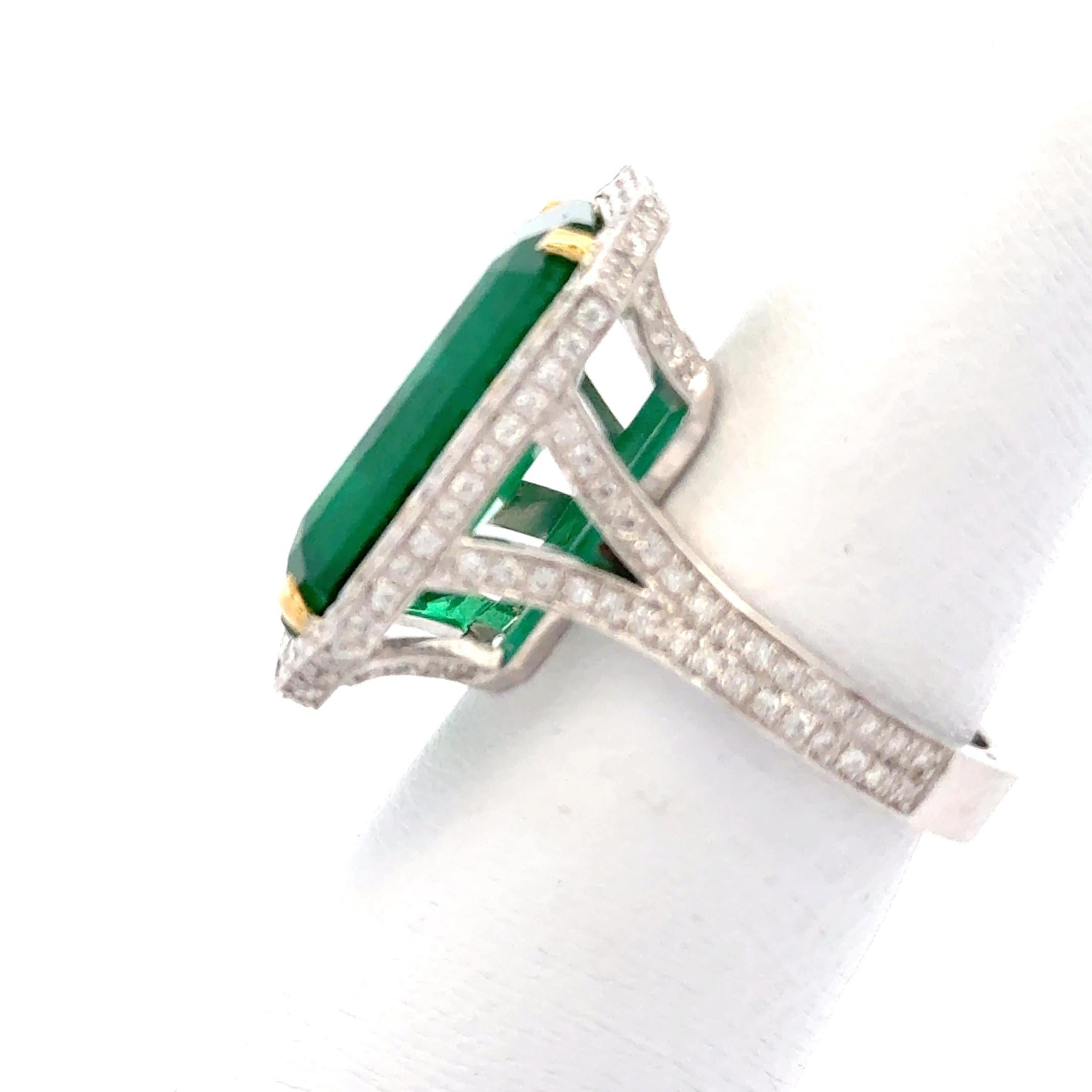 Dieser atemberaubende Ring mit 11 Karat Smaragd und Diamanten zeigt einen leuchtenden, tiefgrünen Smaragd in der Mitte, umgeben von einem funkelnden Halo aus Brillanten. Der Kontrast zwischen dem sattgrünen Edelstein und den schillernden Diamanten