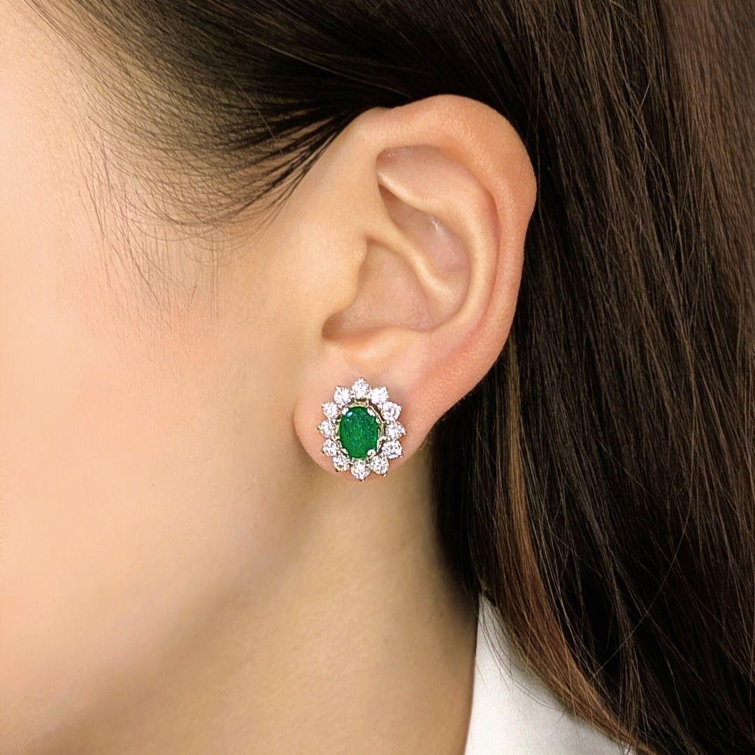 These breathtaking stud earrings showcase timeless elegance with a striking combination of vivid green emeralds and brilliant diamonds. Crafted in 18K white gold, each earring features a natural oval mixed-cut emerald weighing a total of 4.20